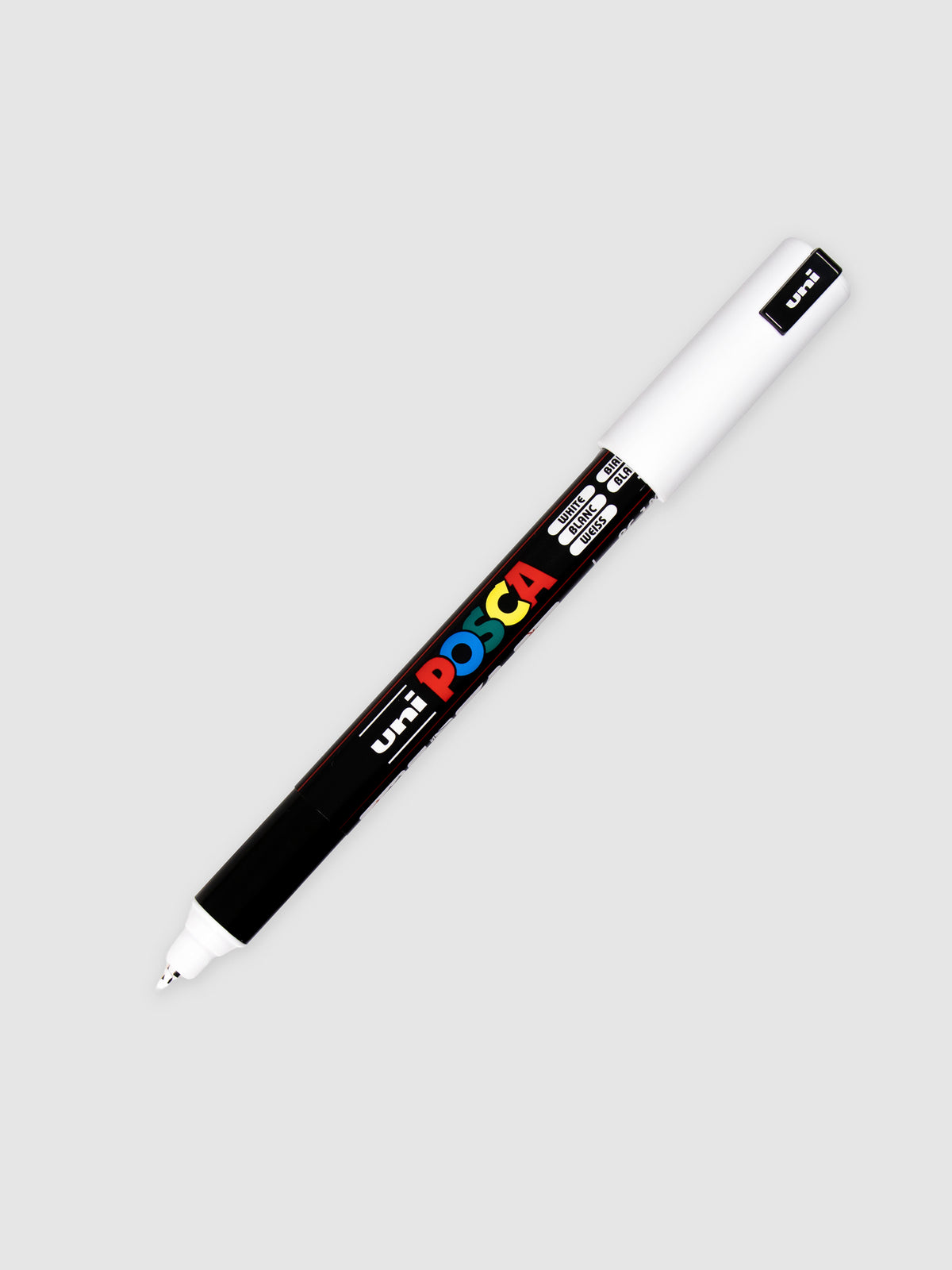 Uni Posca Paint Marker, Ultra Fine Point, White, Cloth and Paper. Uncapped marker with cap posted turned to the right against a neutral background.