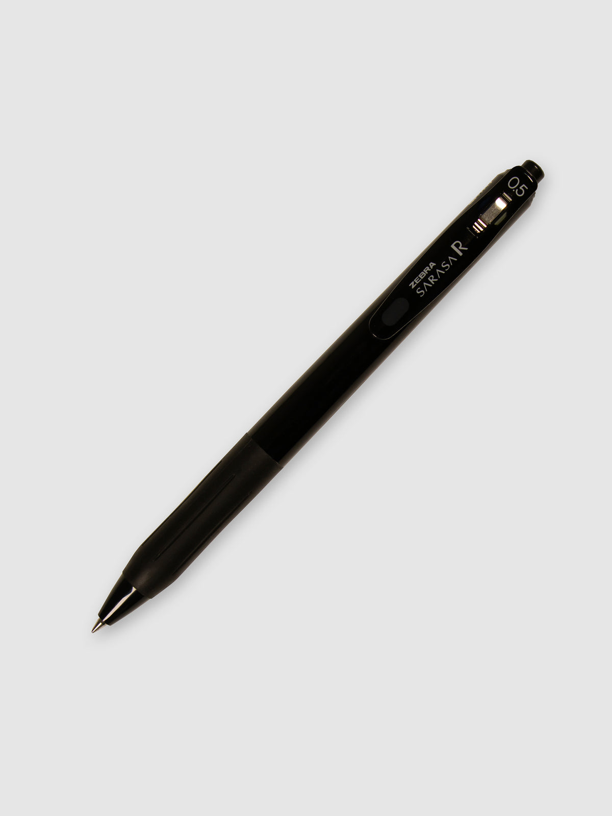 Zebra Sarasa R Pen, 0.5 mm, Black Ink, Black Body, Cloth and Paper. Pen with nib exposed turned to the right against a neutral background.