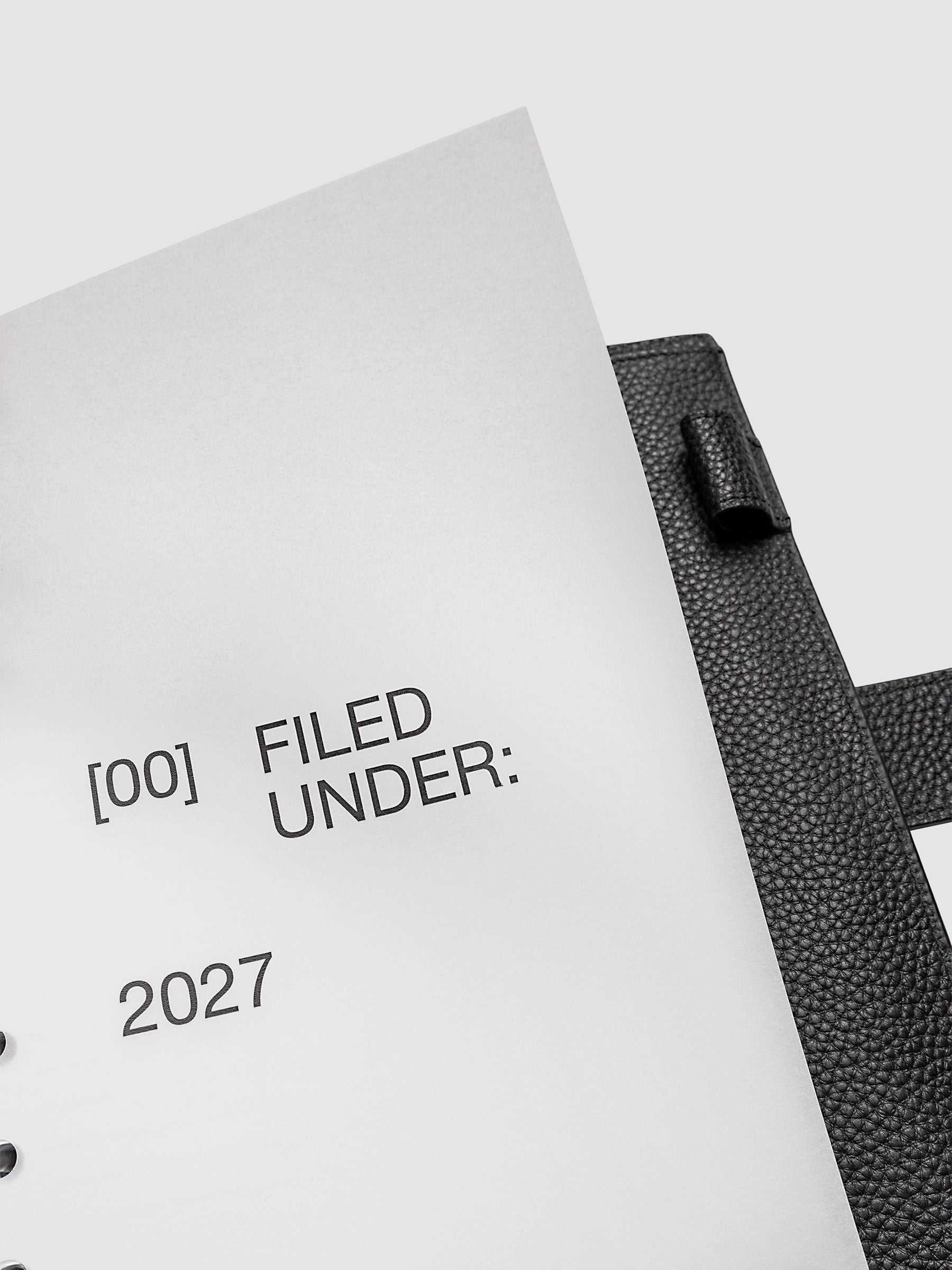 2027 Front + Monthly Dashboard Overlays, Avant Garde, Half Letter 8-Disc Punch, close-up of a vellum dashboard overlay lifted to show the translucent layering effect inside a planner