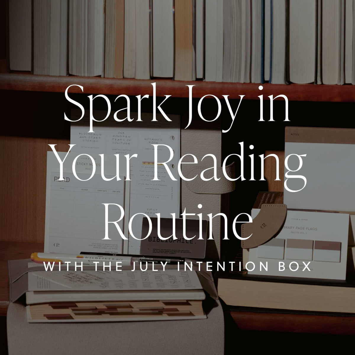 An image of a July Intention Box items laid in front of a full book shelf with a text overlay that reads: Spark Joy in Your Reading Routine with the July Intention Box.