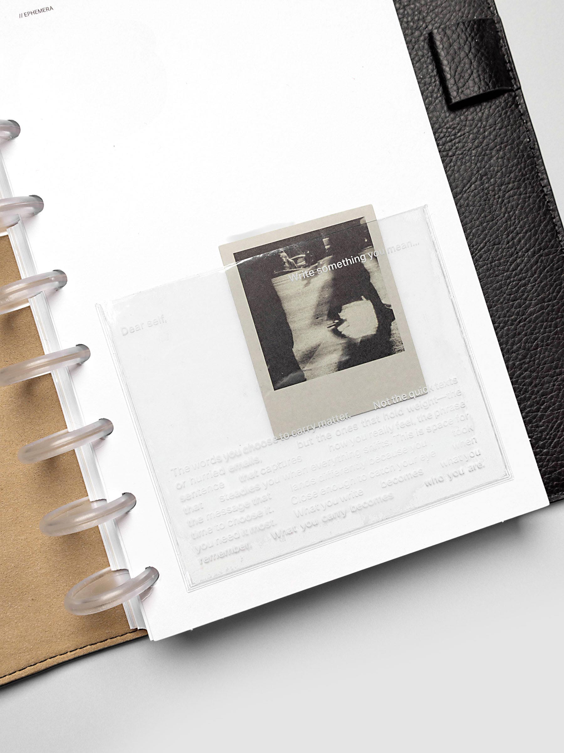 Close up of the white Ephemera Planner Dashboard shown in size Half Letter in a black leather folio.