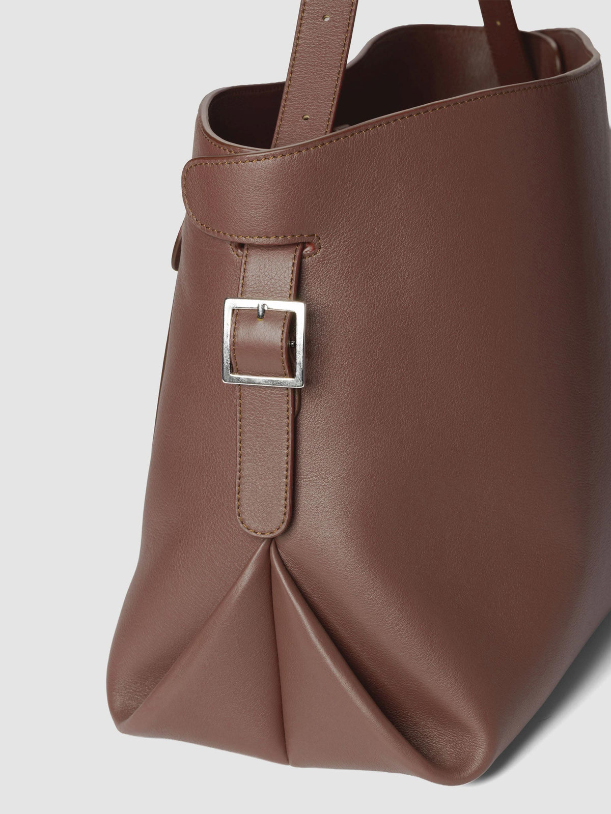 Detail view of the side buckle on The Metro Tote in the color Cordoba.