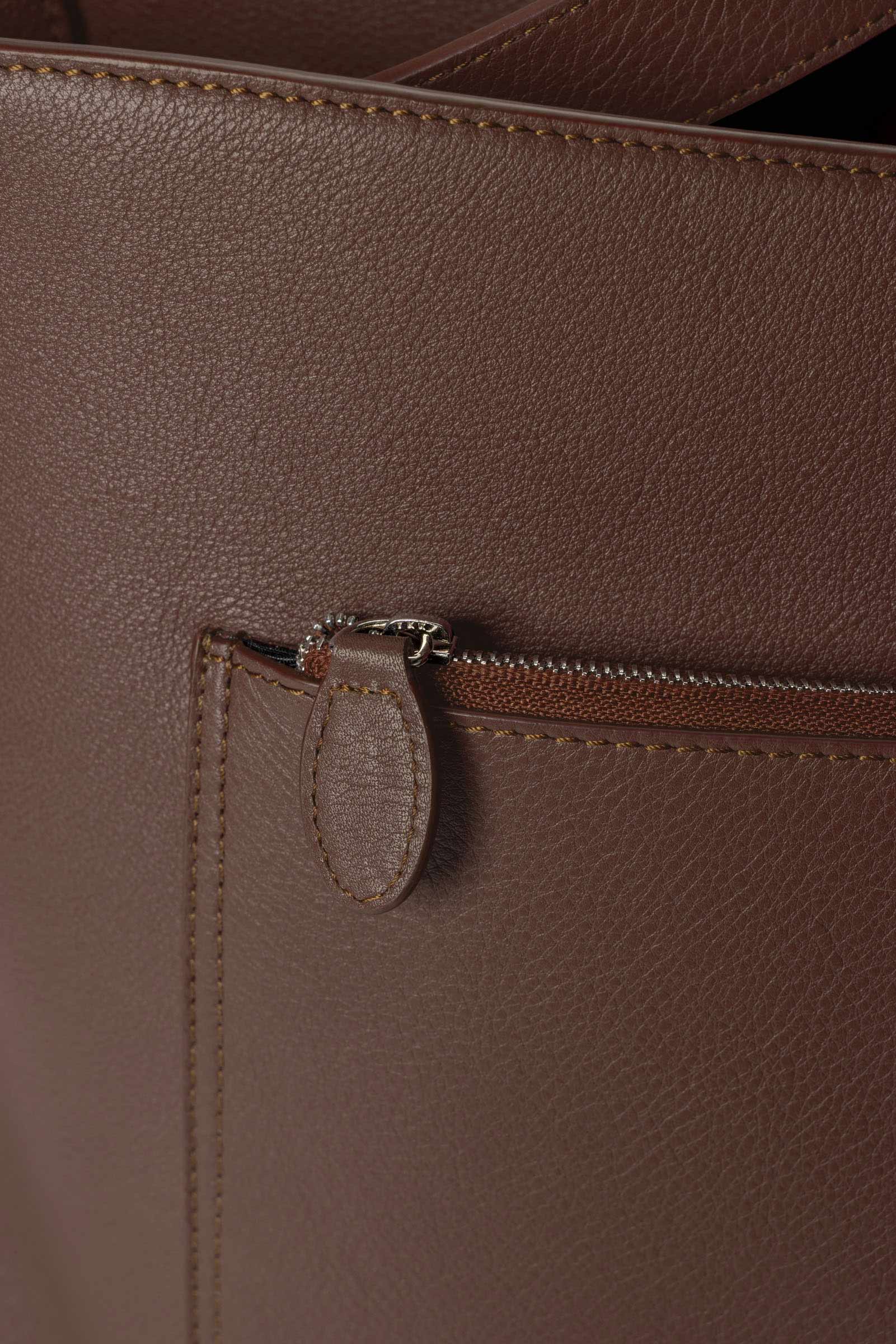 Detail view of the zip closure pocket on The Metro Tote in the color Cordoba.