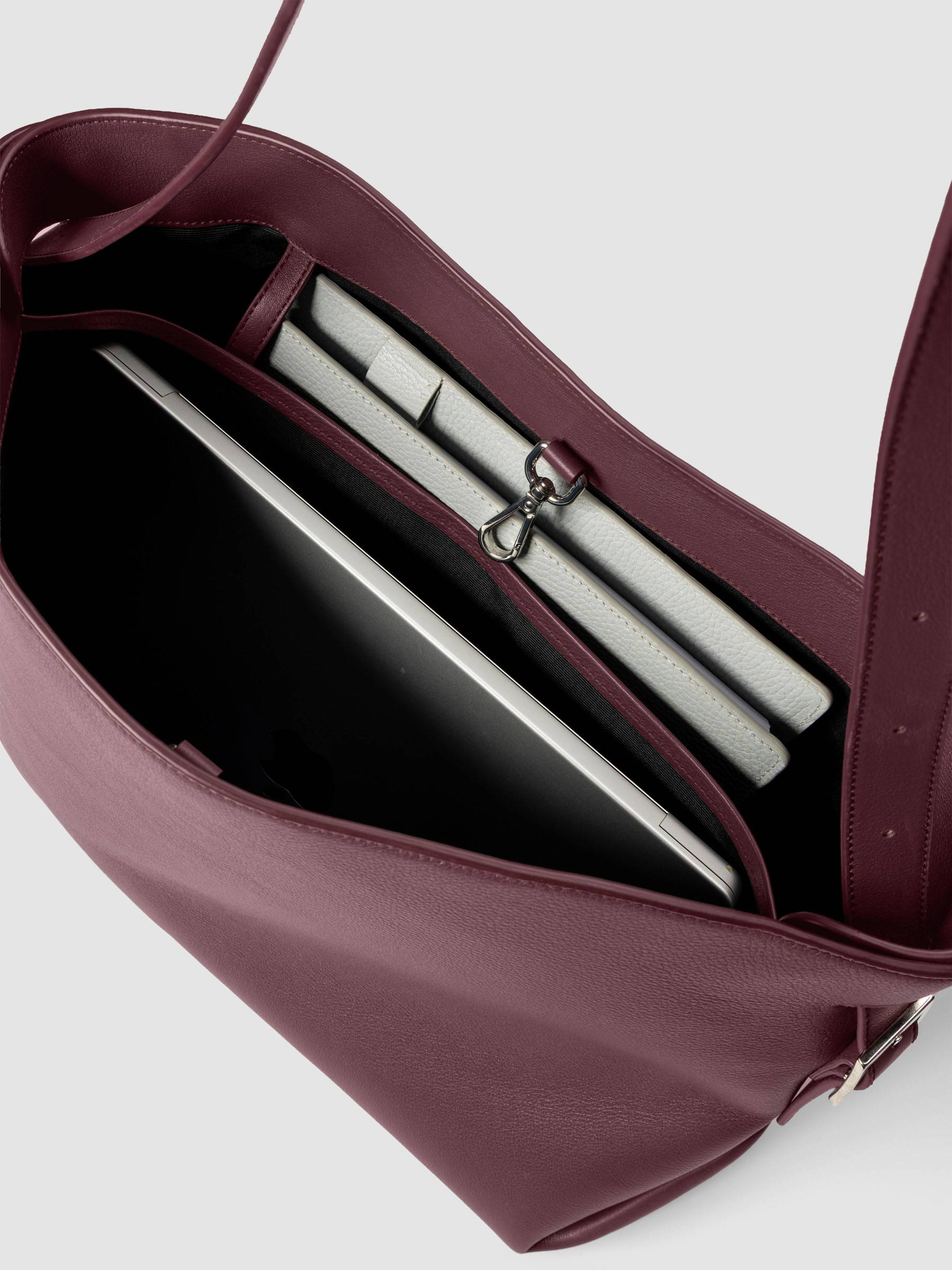 Detail view of a laptop and notebooks inside The Metro Tote in the color Madrid.