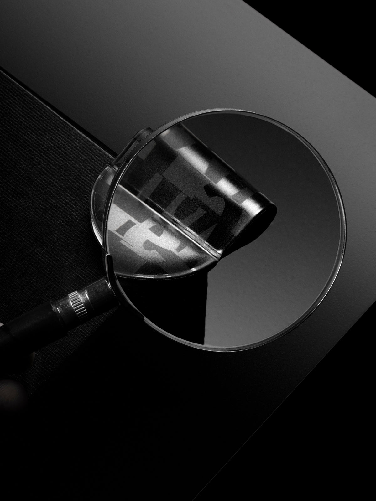 Magnifying glass examining the magnetic bookmark pen holder in the pattern torn magazine
