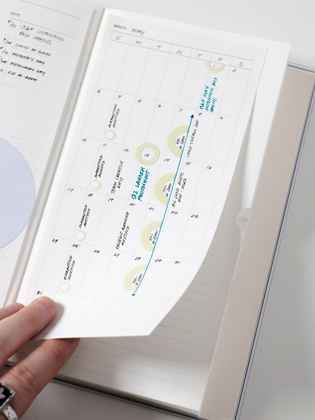 Monthly calendar sticky note in use in a notebook with handwritten planning notes