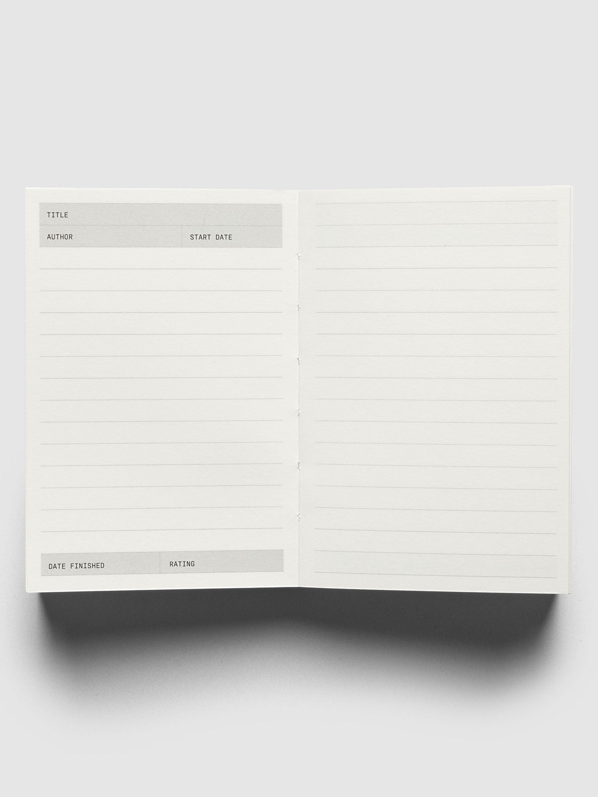 Bibliophile Notebook Pocket, open to a blank reading log spread, title, author and start date at the top and a lined facing page