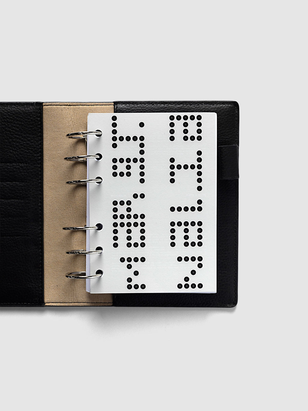 Scantron Dashboard Duo, A6 6-Ring Punch, the dashboard pair on the rings of an open black leather planner