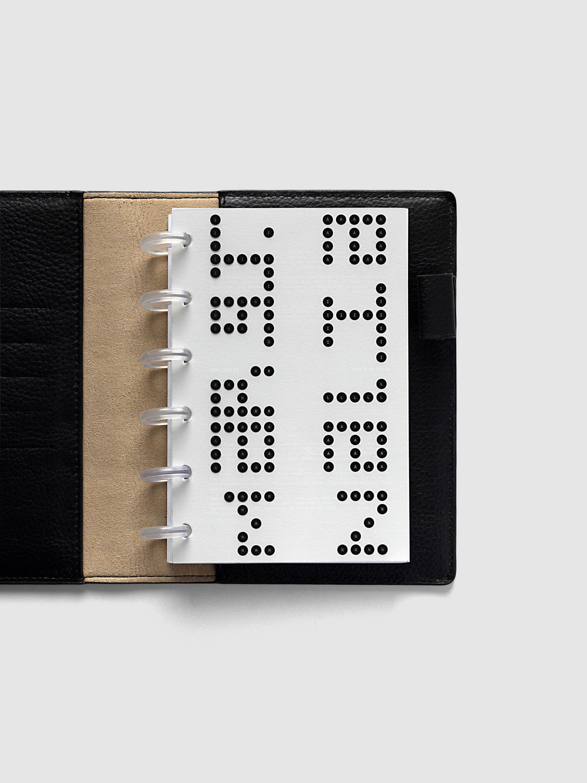 Scantron Dashboard Duo, CP Petite 6-Disc Punch, the dashboard pair on frosted discs in an open black leather planner with a kraft interior panel