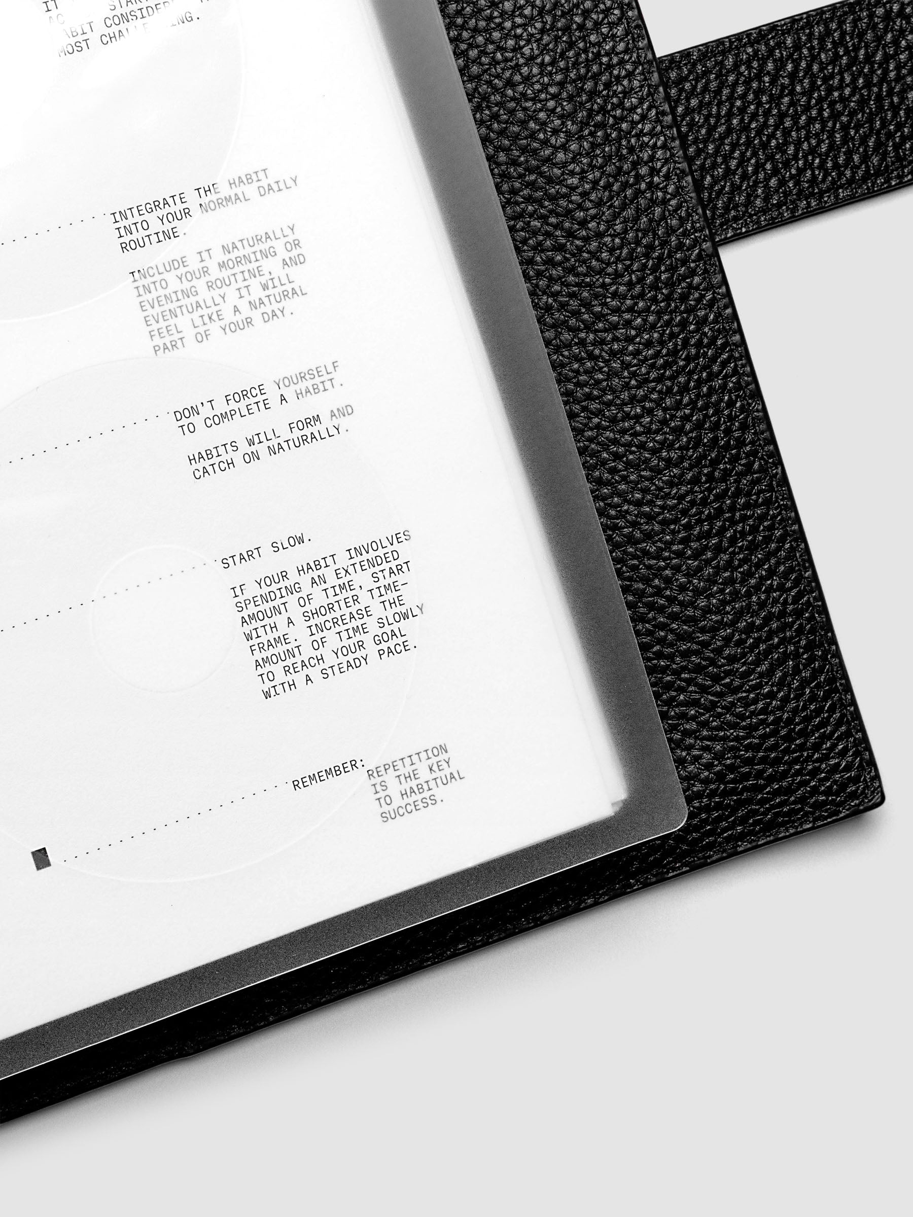 Close up view of a clear planner cover and white paper dashboard with black printed text design.