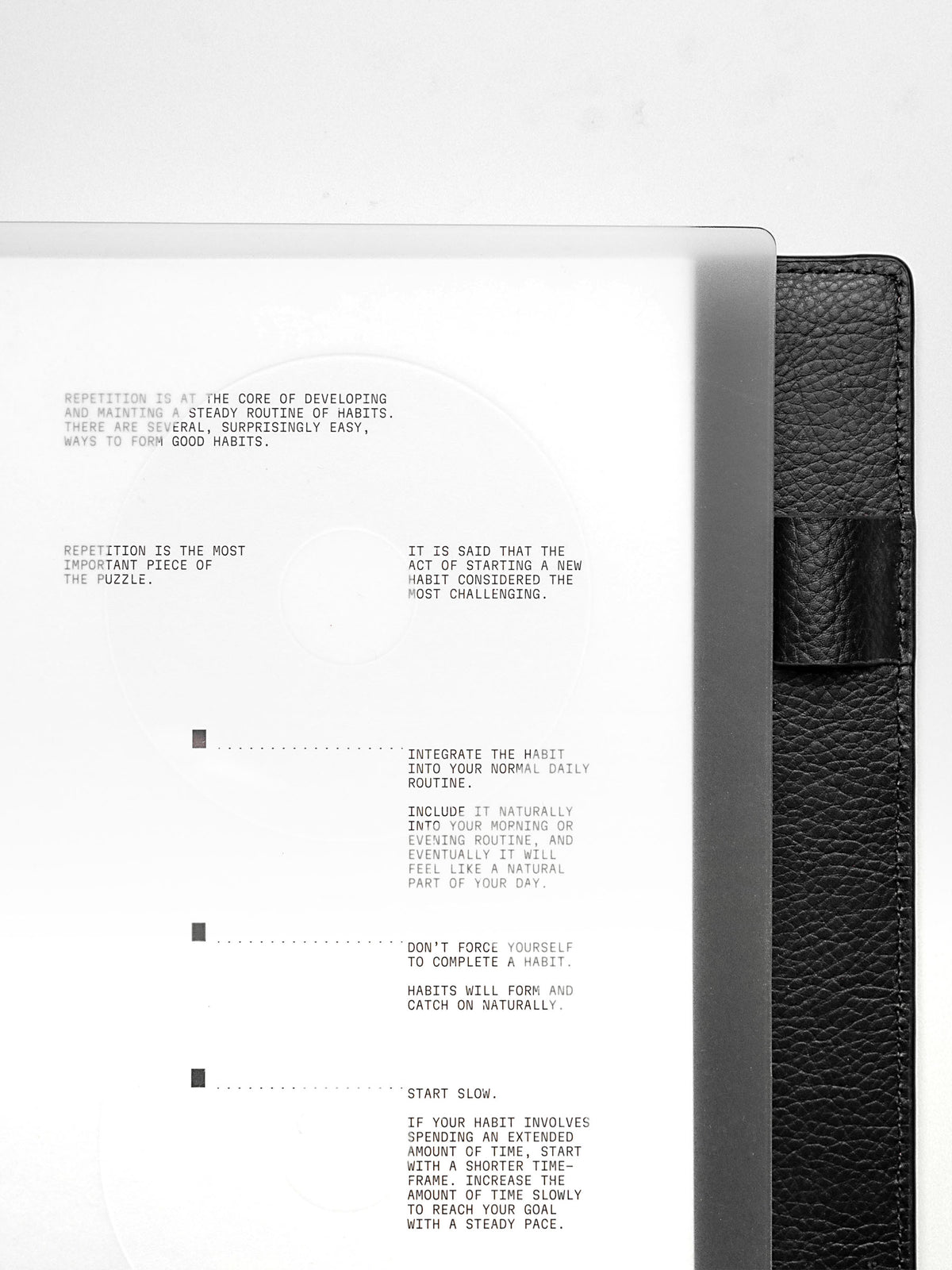 Close up view of a clear planner cover and white paper dashboard with black printed text design.