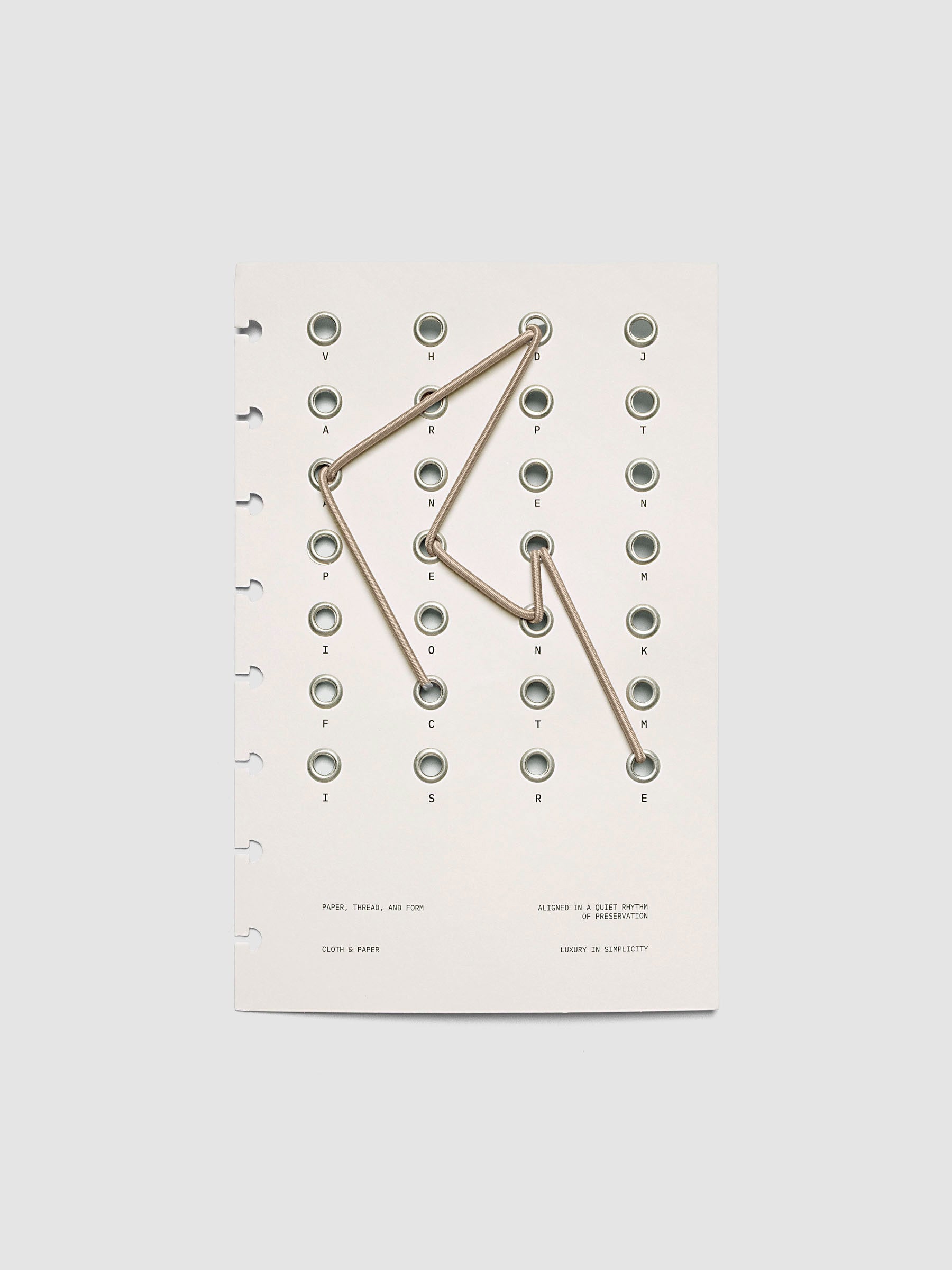 Cadence Dashboard with grommets and string on beige cardstock shown in size Half Letter for discbound planners and notebooks.