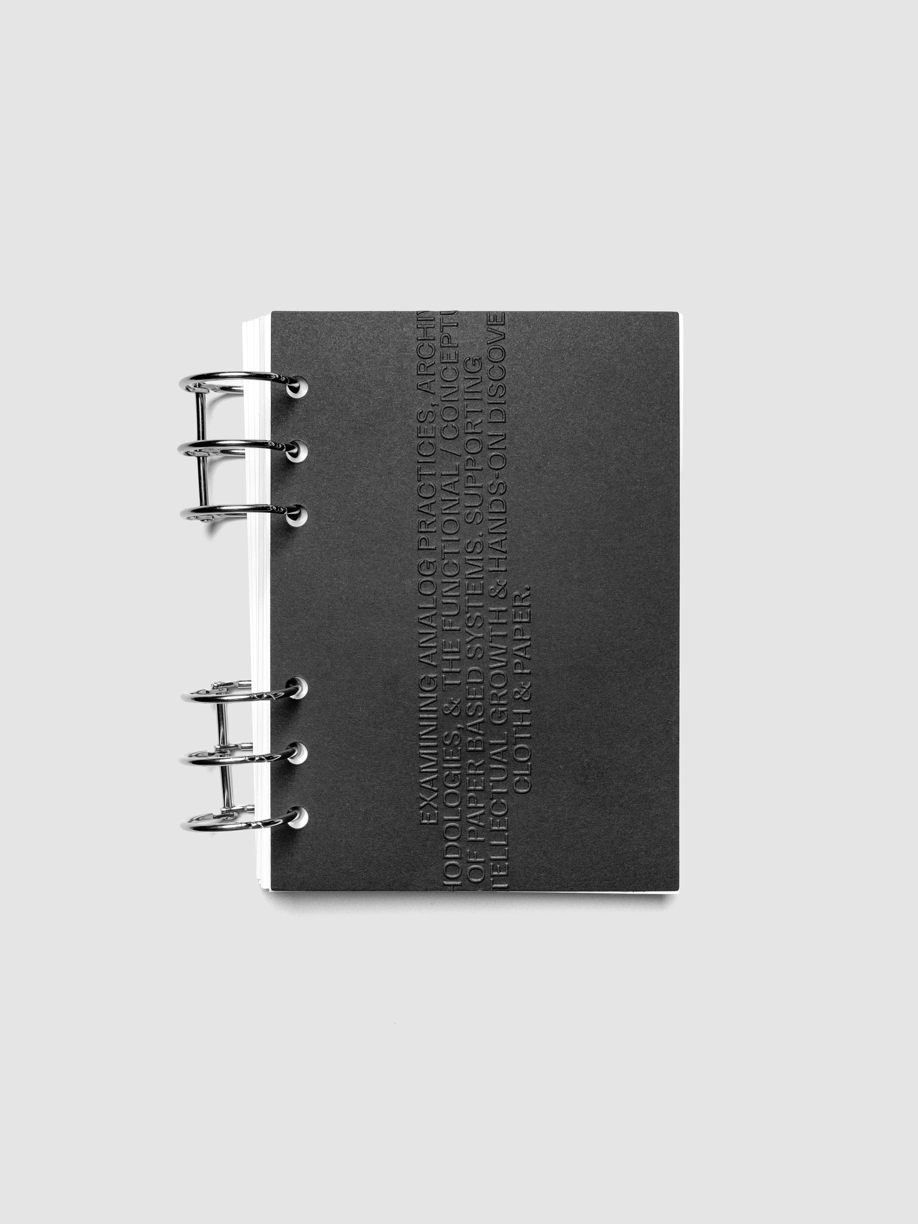 Black embossed Analog Embossed Planner Dashboard without the drop card shown in size Personal Wide.