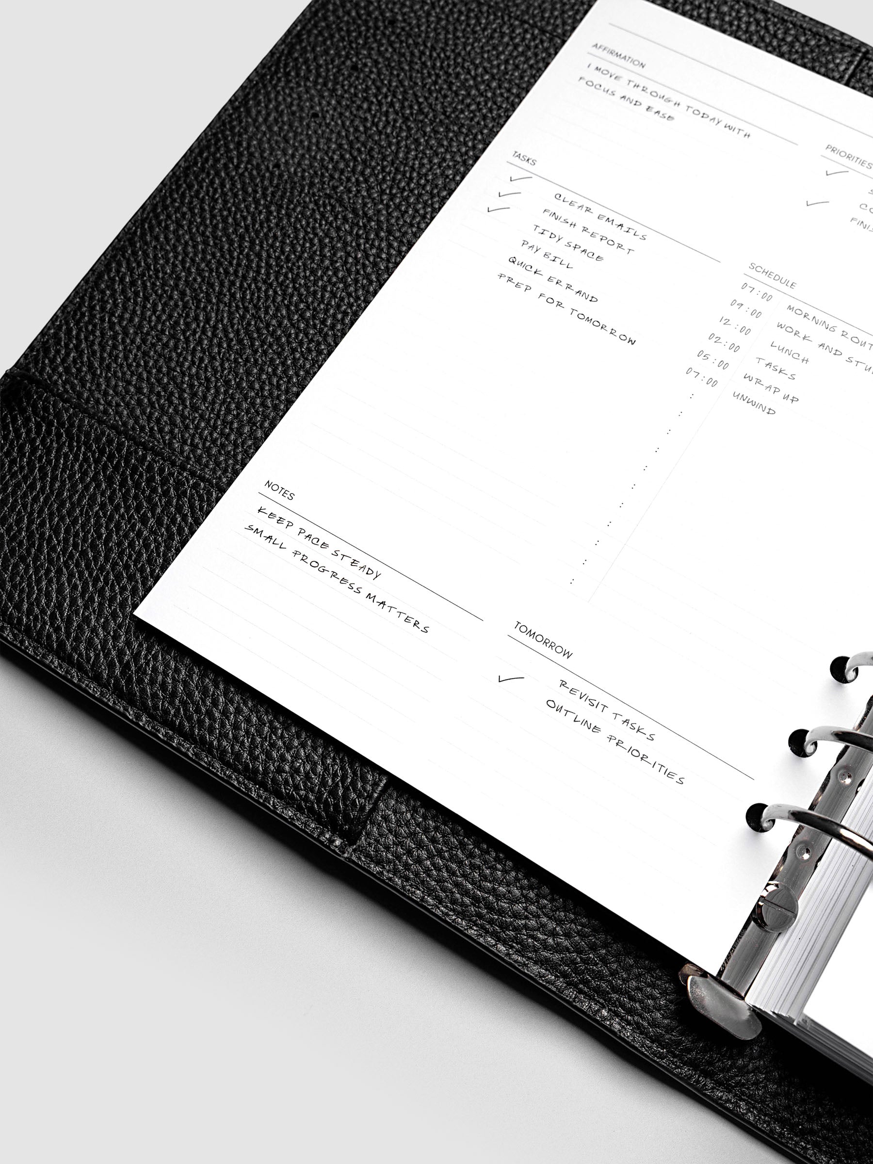 Close up of the demo page for the Daily Essentials Planner insert inside an A5 black agenda.