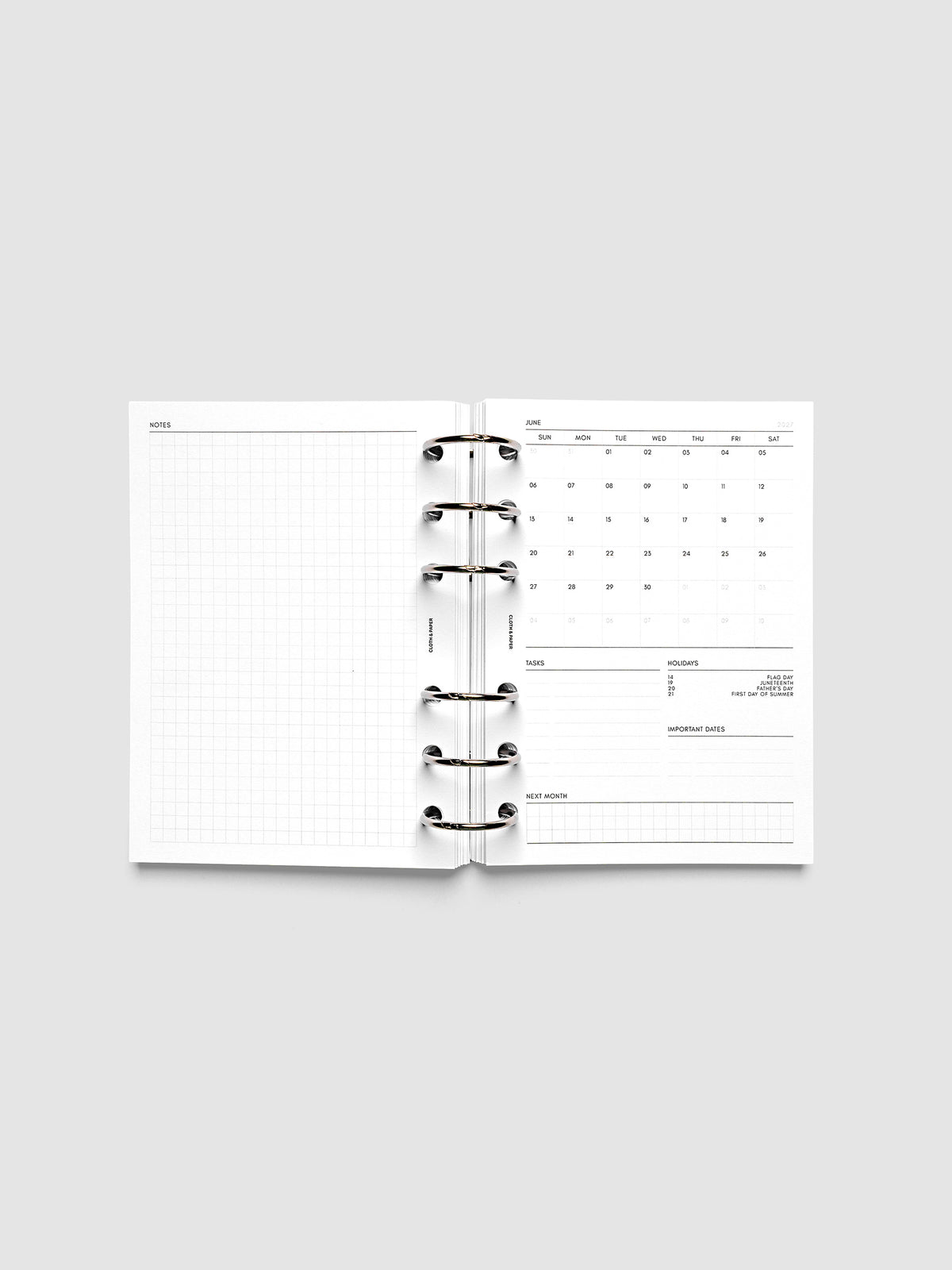 2027 Dated Monthly Admin Inserts open inside a A6 6-Ring Punch 6-ring planner, showing the fully open graph left page alongside the Sunday start monthly calendar, task section, holiday reference, important dates, and next month preview on the right.