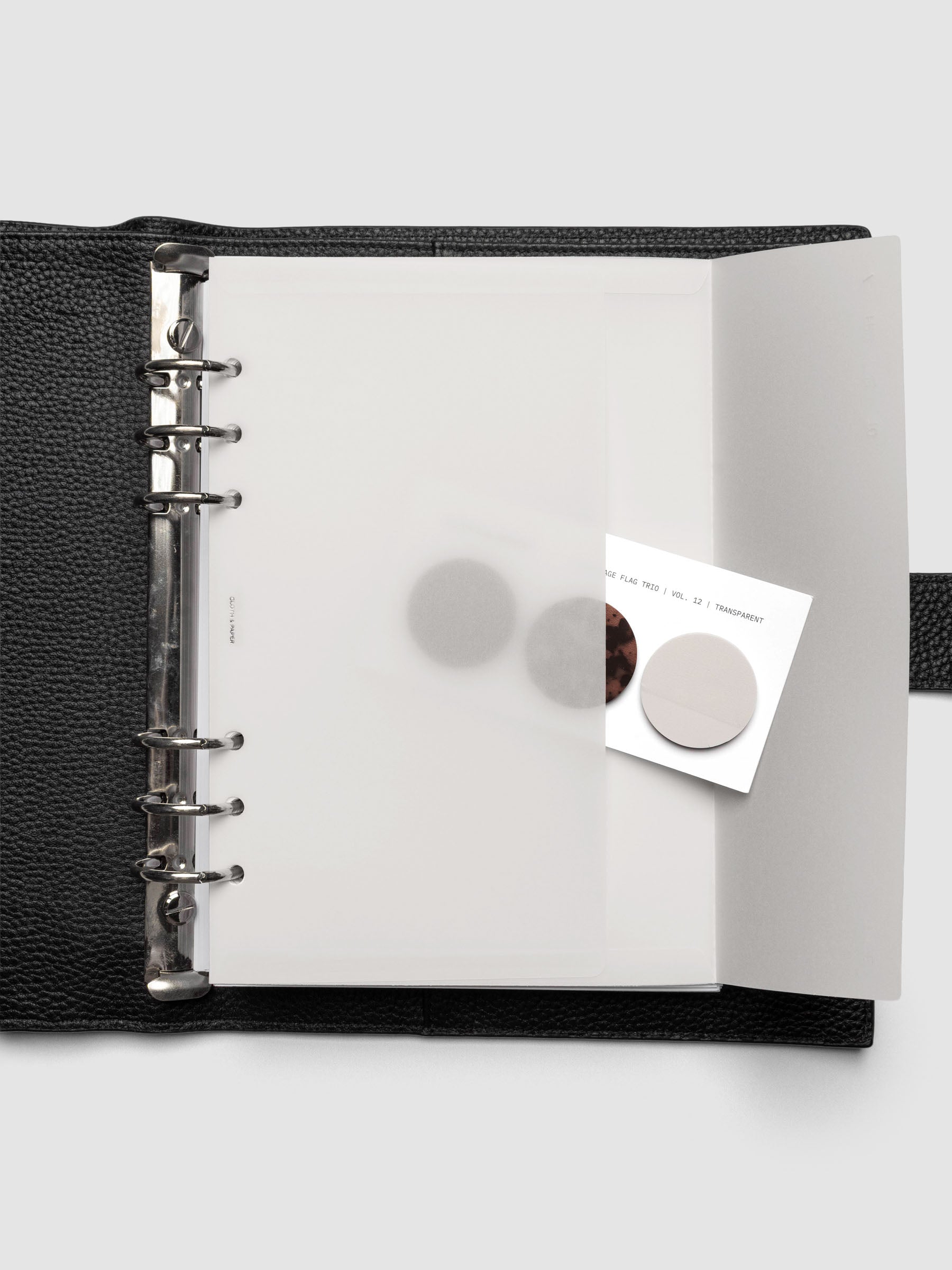 White Envelope Storage Holder shown inside a black, leather A5 agenda with page flags inside.