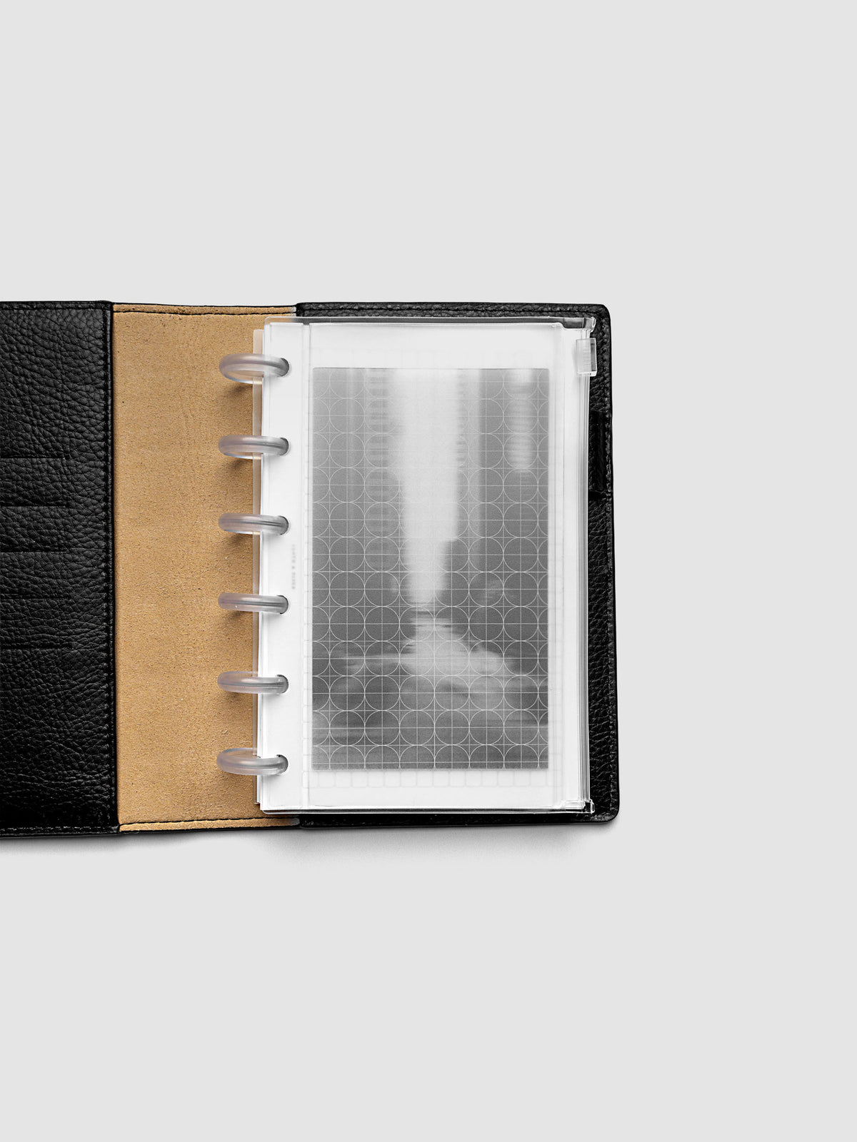 Side zipper transparent storage pouch for planners with decorative inner graph and photograph layers shown in a CP Petite planner folio cover.