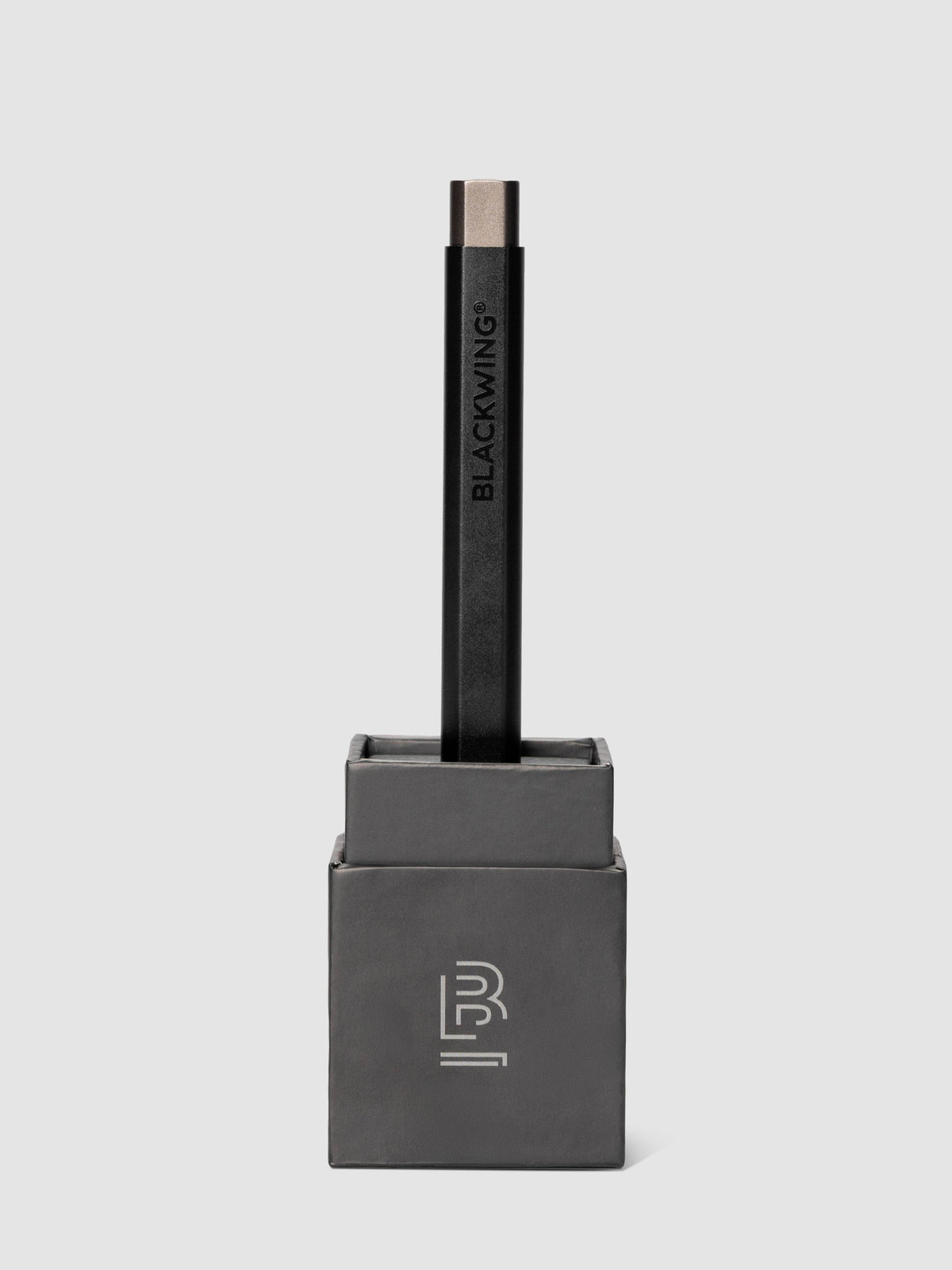 Blackwing Pen in the color black shown standing, inserted into the packaging box's base.