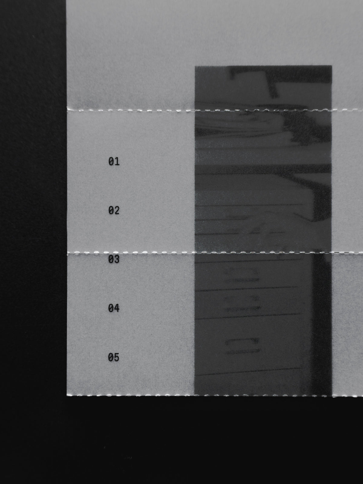 The Pending Review Journaling Card, a sheet of frosted vellum printed with a grayscale file cabinet image and divided by perforated lines numbered 01 through 05, on a black surface.