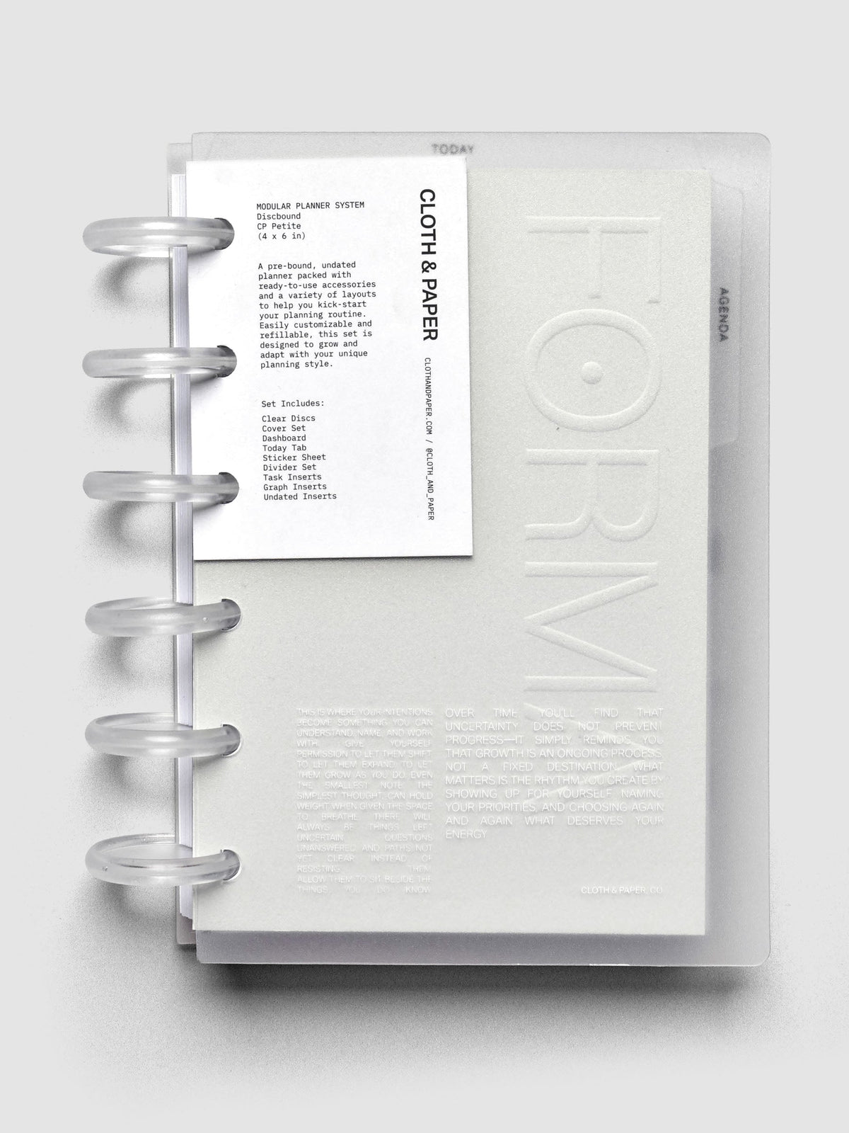 CP Petite Forma Modular Planner with six discs, clear cover with printed text, neutral dashboard labeled ‘Forma,’ top tab Today divider, and three side tab dividers, shown against a neutral grey background with a contents tag attached to the front.