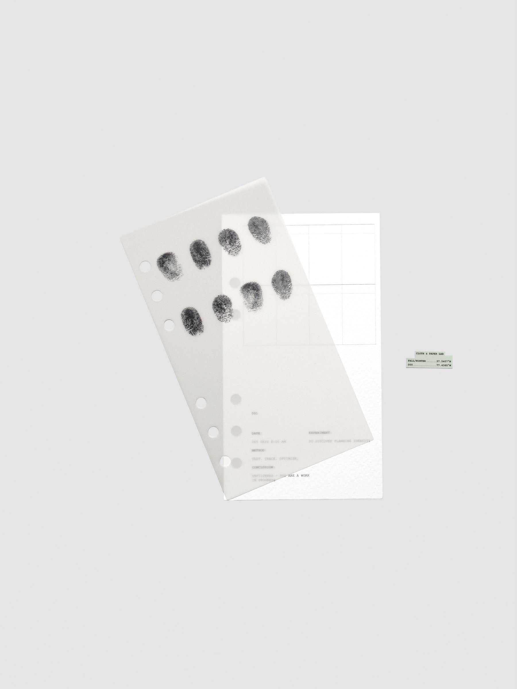 Two layered Personal sized planner dashboards, one semi-transparent, one matte, featuring a fingerprint design shown offset from one another.