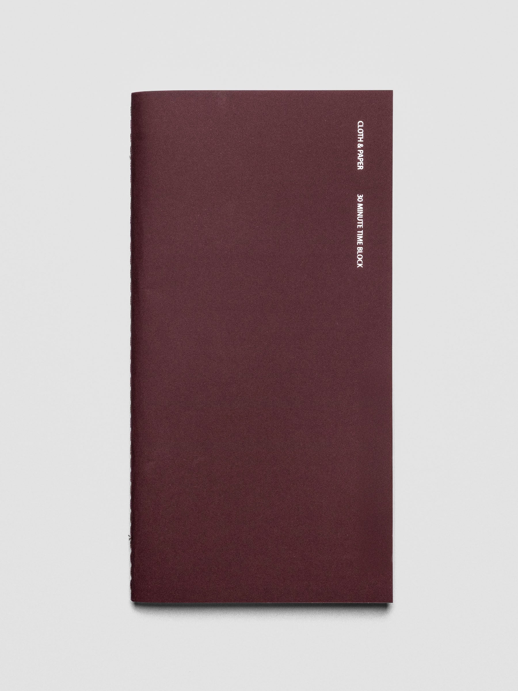 Travel Notebook in size A5 Slim in color Bordeaux with 30 Minute Time Block pages shown from the front.