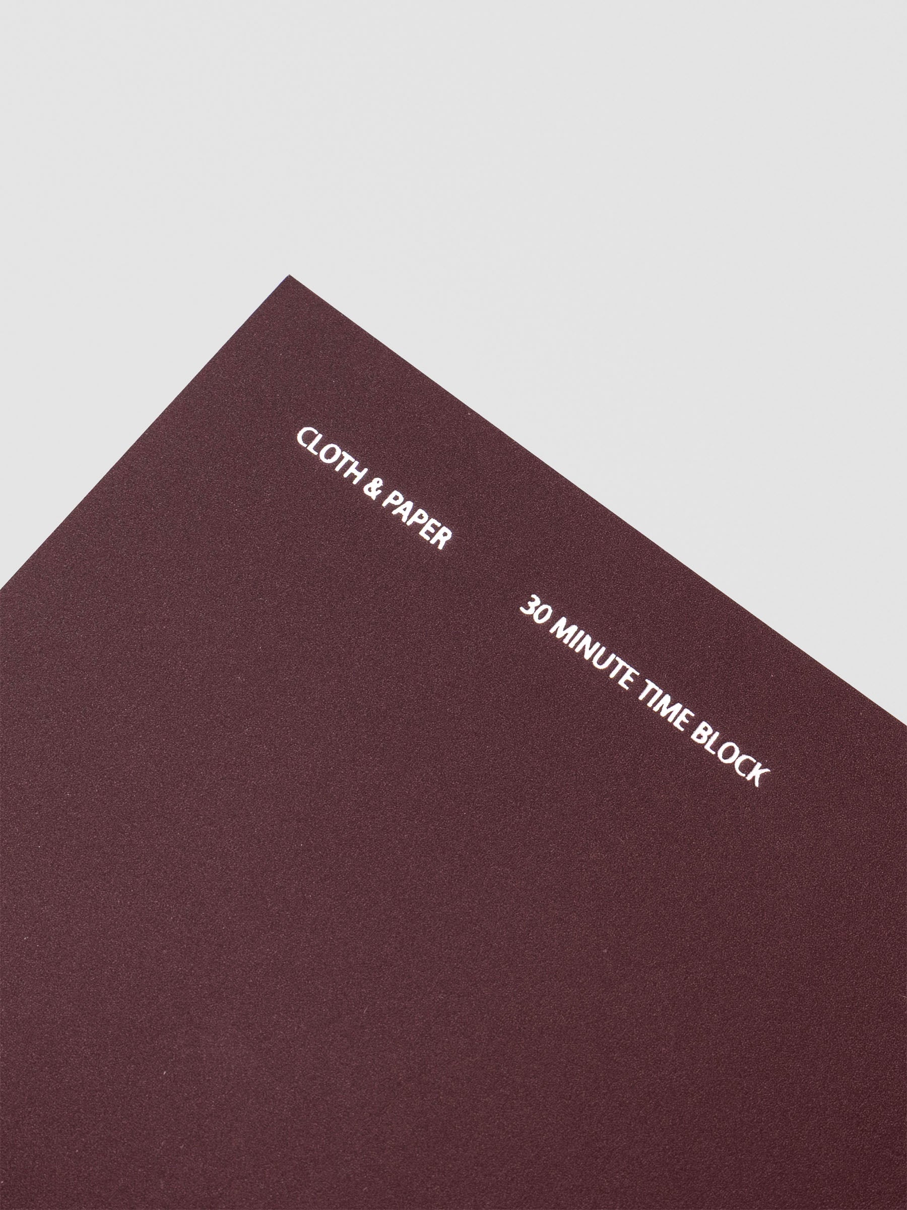 Travel Notebook in size A5 Slim in color Bordeaux with 30 Minute Time Block pages shown from the front as a close up.