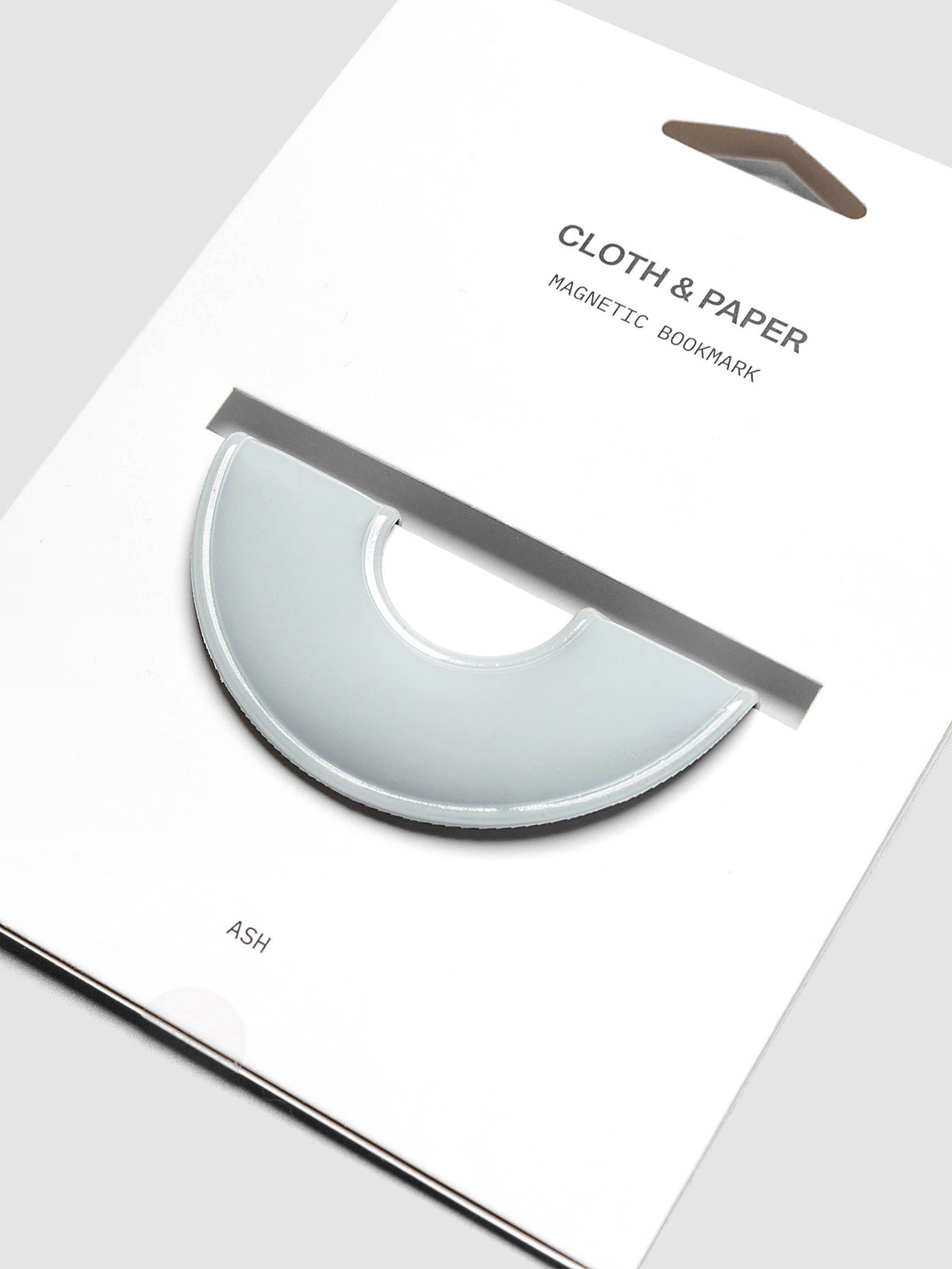 Magnetic Bookmark | Spotlight in the color Ash, a light grey, shown on a backing card