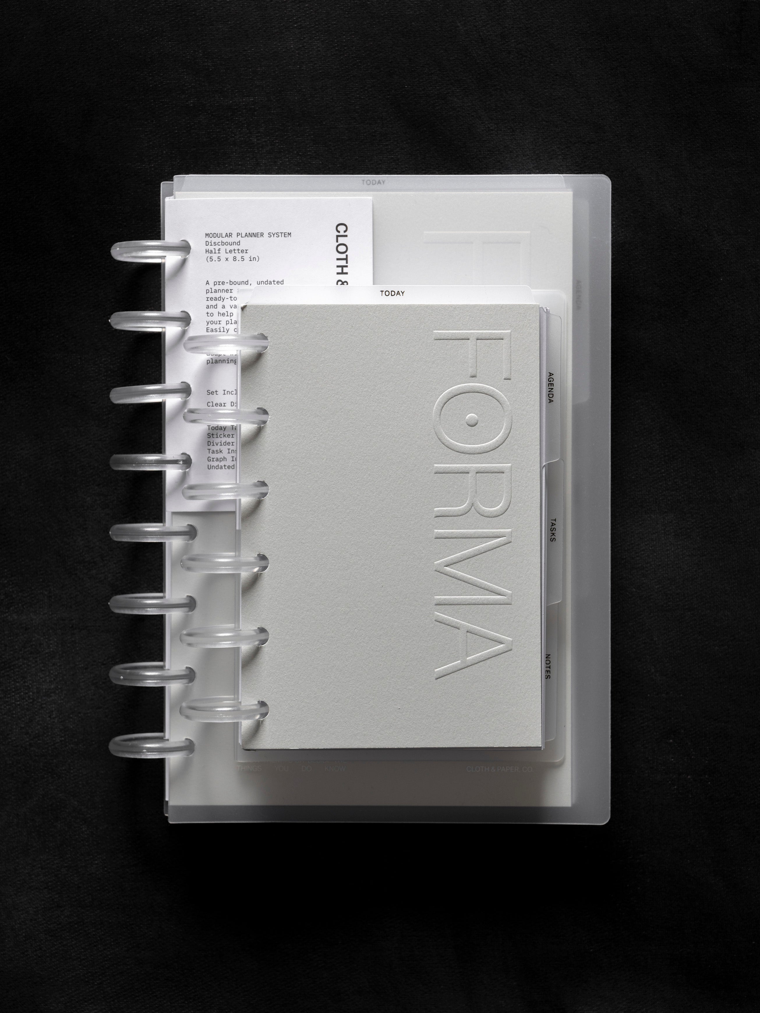 Forma Modular Planner System in CP Petite shown on top of Half Letter against a black background.