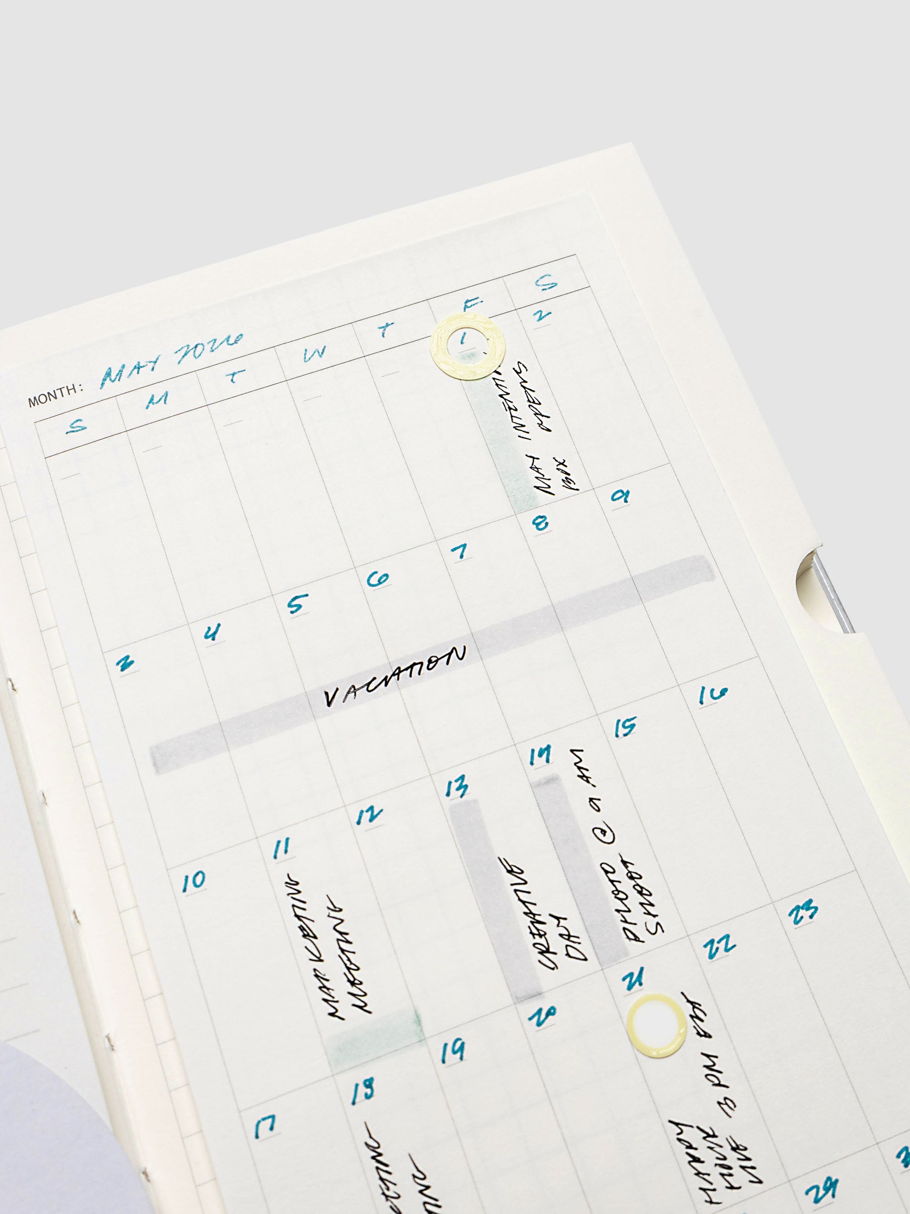 Monthly calendar sticky note in use in a notebook with handwritten planning notes