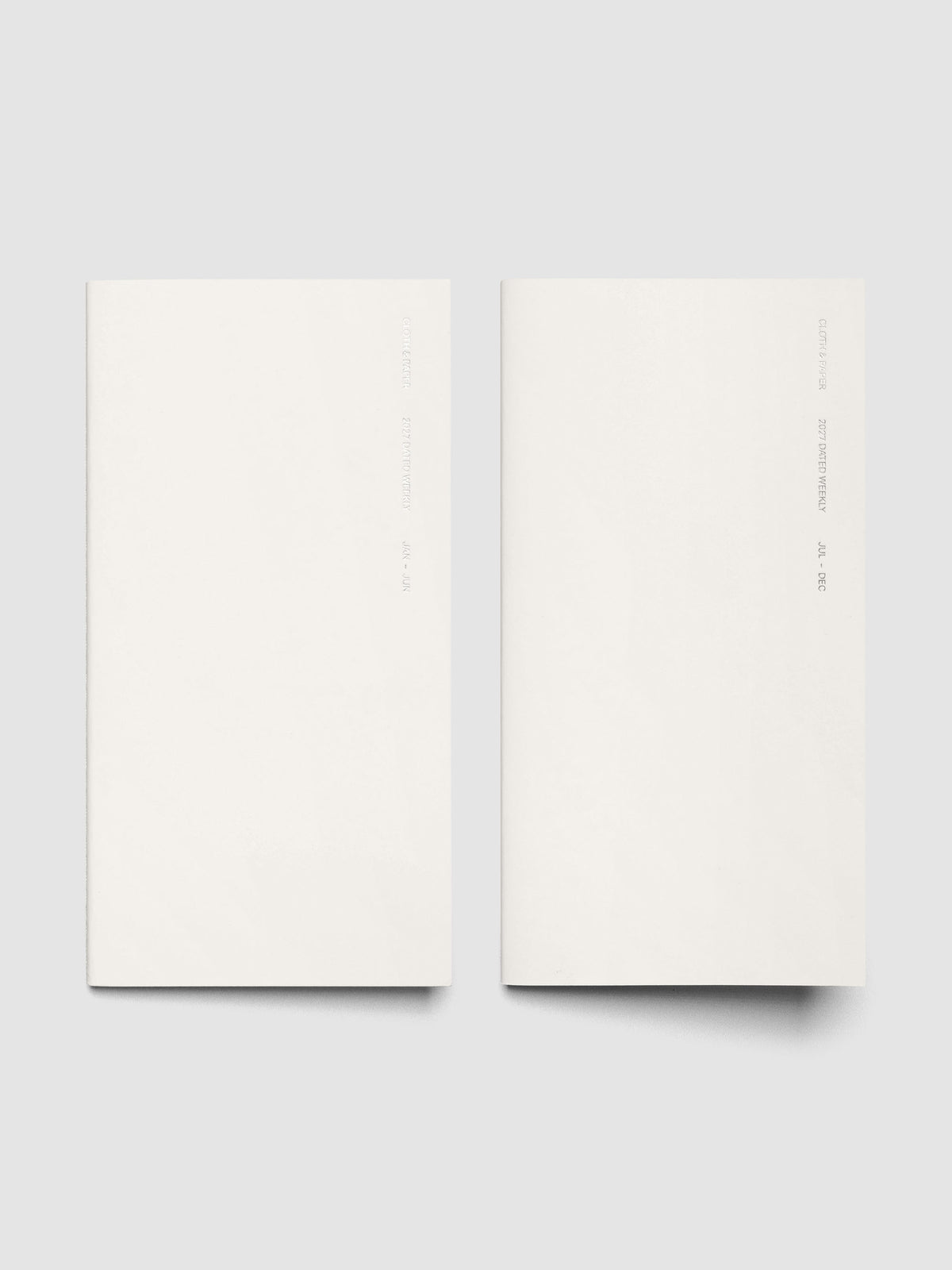 Both 2027 Dated Travel Notebooks in A5 Slim size displayed side by side, showing the off-white covers with silver foil text for the Jan–Jun and Jul–Dec volumes