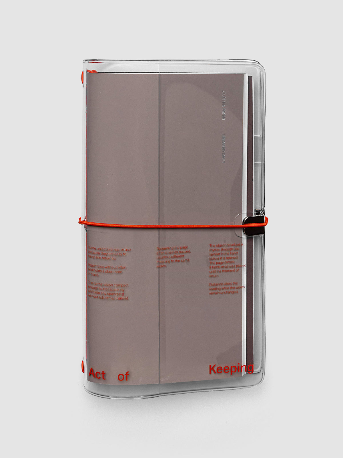 Act of Keeping Travel Notebook Cover in A5 Slim size, clear vinyl with deep orange bands, shown holding travel notebooks