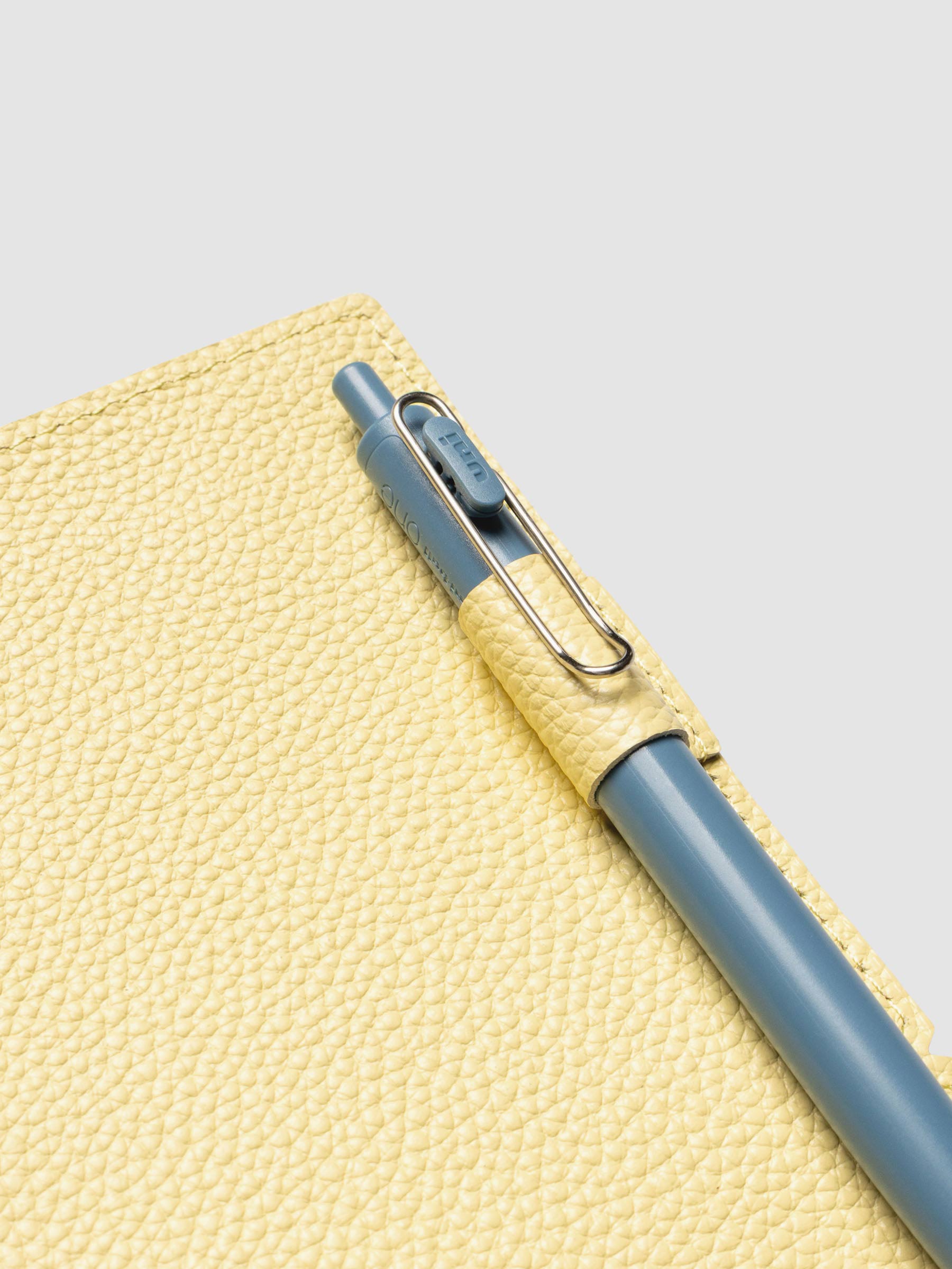 Butter yellow leather travel notebook cover in size A5 Slim shown open with a pen in the pen loop.