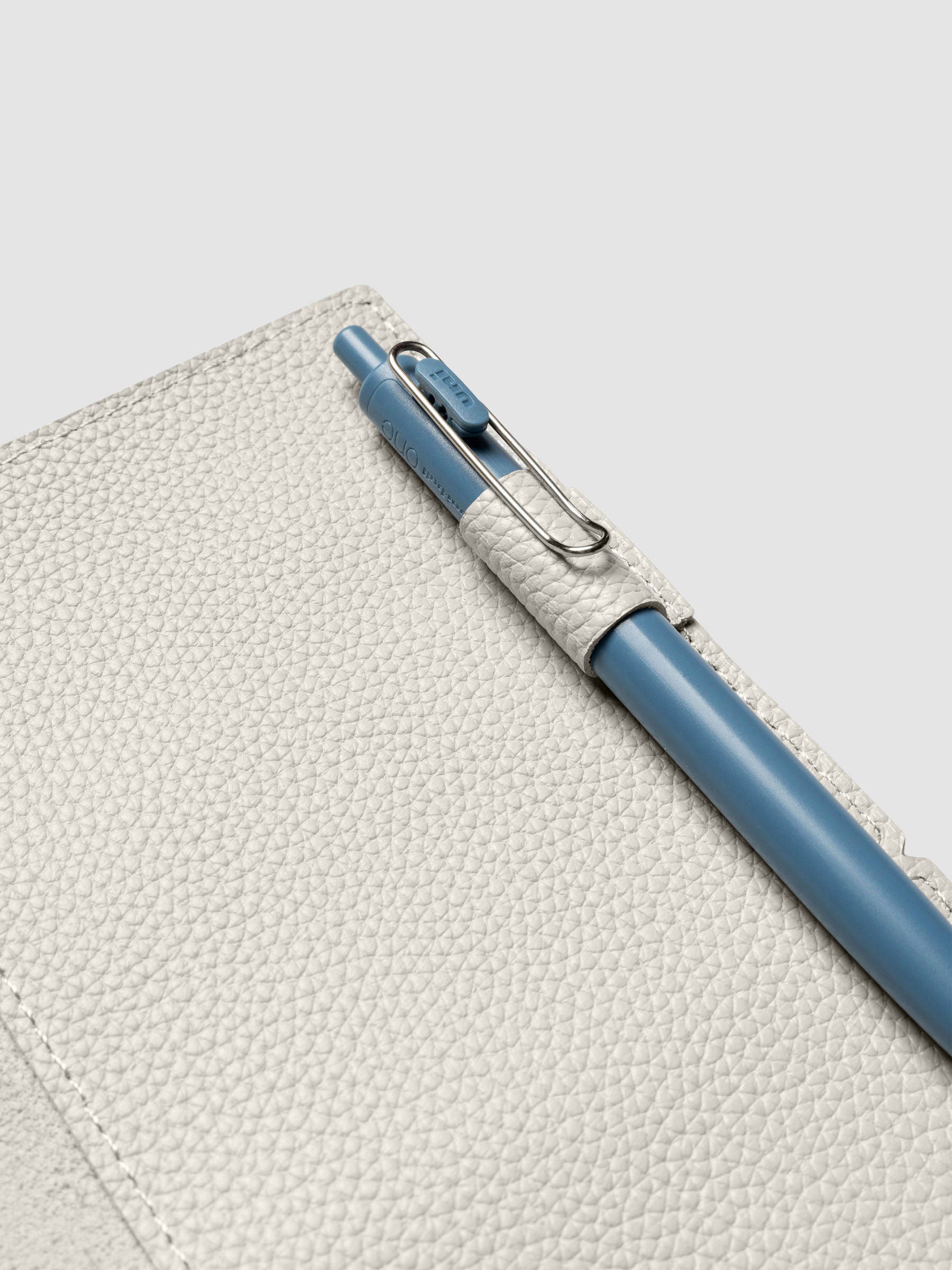Light grey leather travel notebook cover in size A5 Slim shown open with a pen in the pen loop.