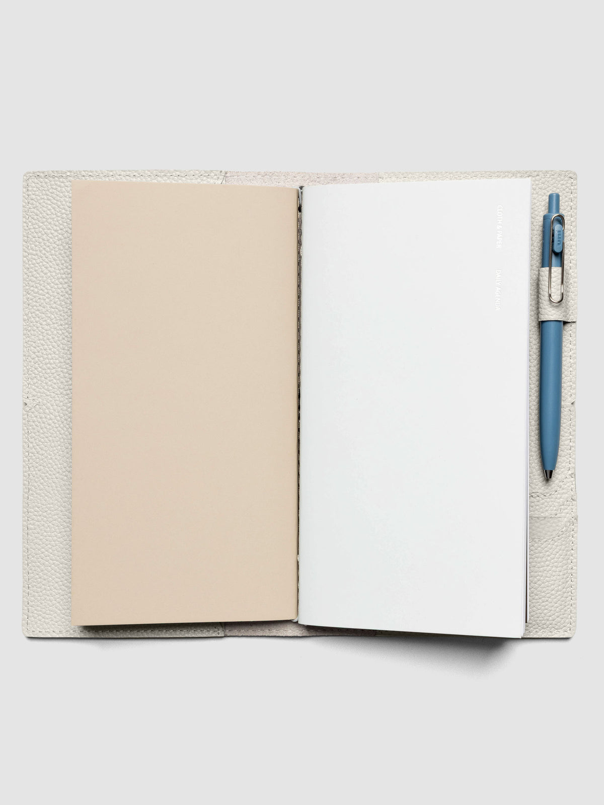 Light grey leather travel notebook cover in size A5 Slim shown with travel notebooks inside.