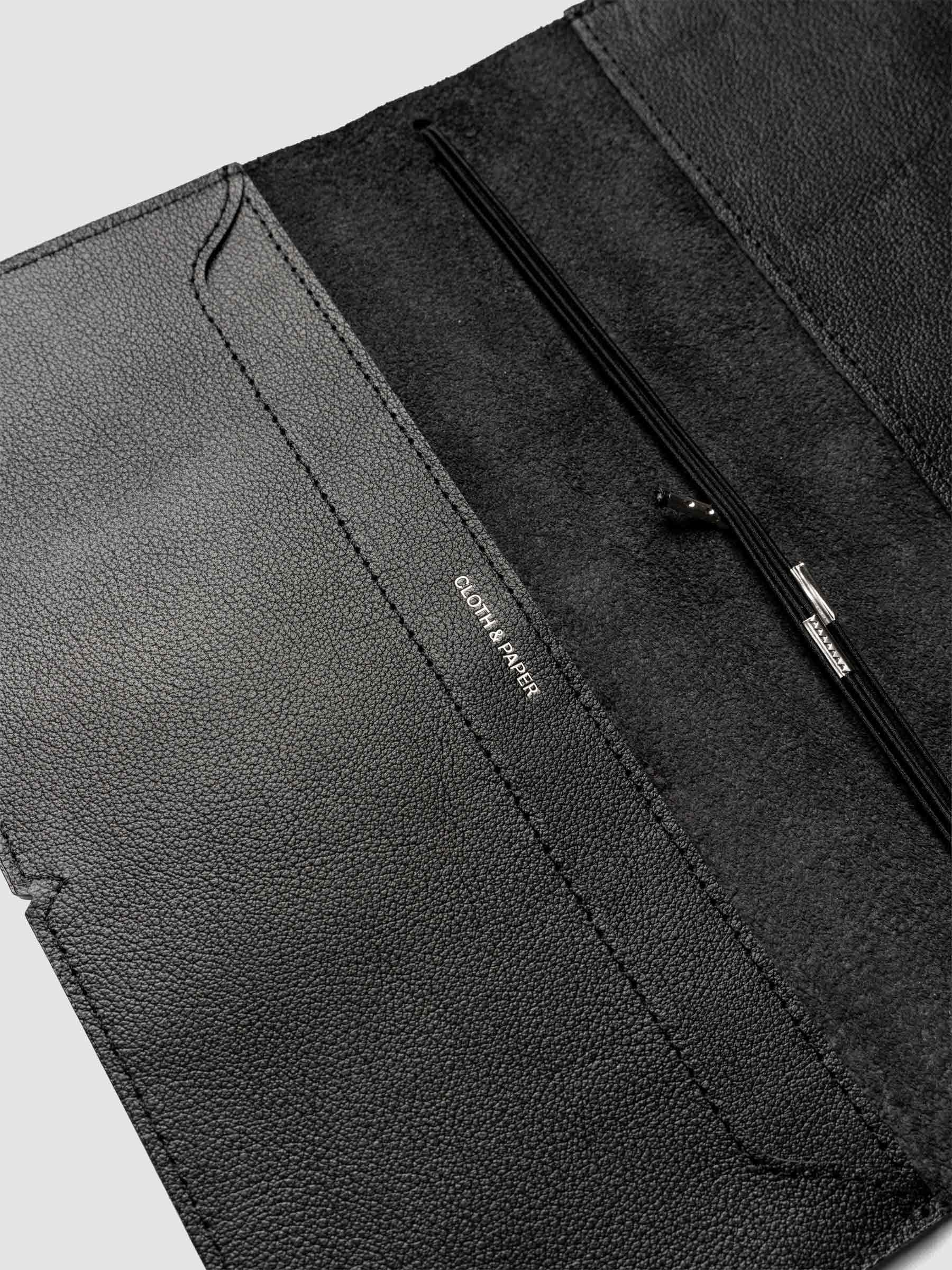 Black leather travel notebook cover in size A5 Slim shown open with interior pockes and elastic bands.