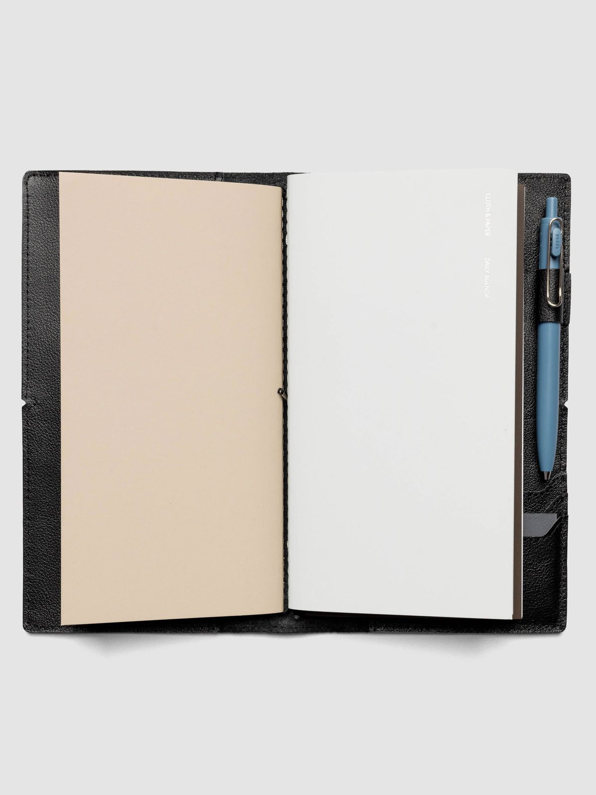 Black leather travel notebook cover in size A5 Slim shown with travel notebooks inside.