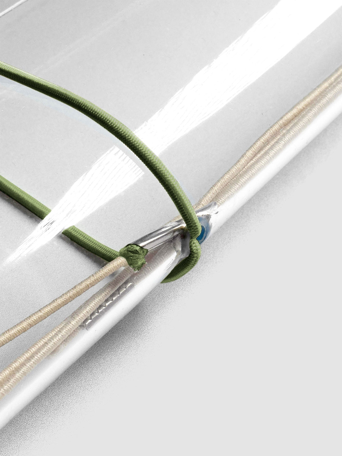Dark green elastic exterior band looped through clear vinyl travel cover spine.