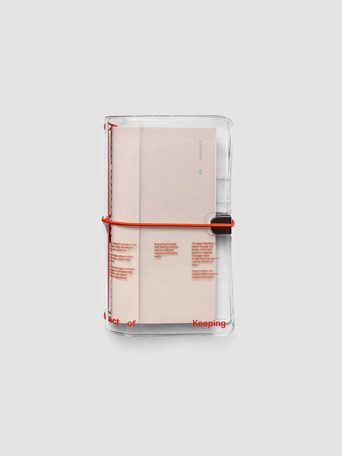 Act of Keeping Travel Notebook Cover in clear vinyl with deep orange bands, shown holding travel notebooks