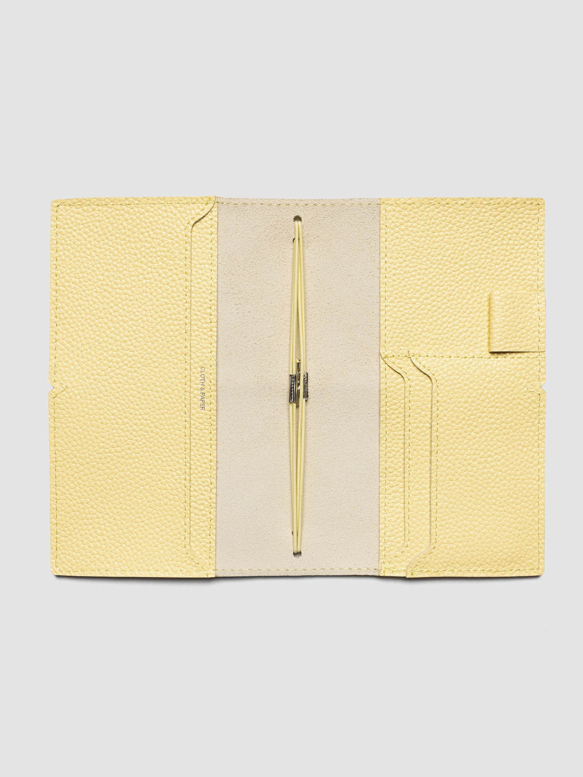 Butter yellow leather travel notebook cover in size Pocket Plus shown open with interior pockes and elastic bands.