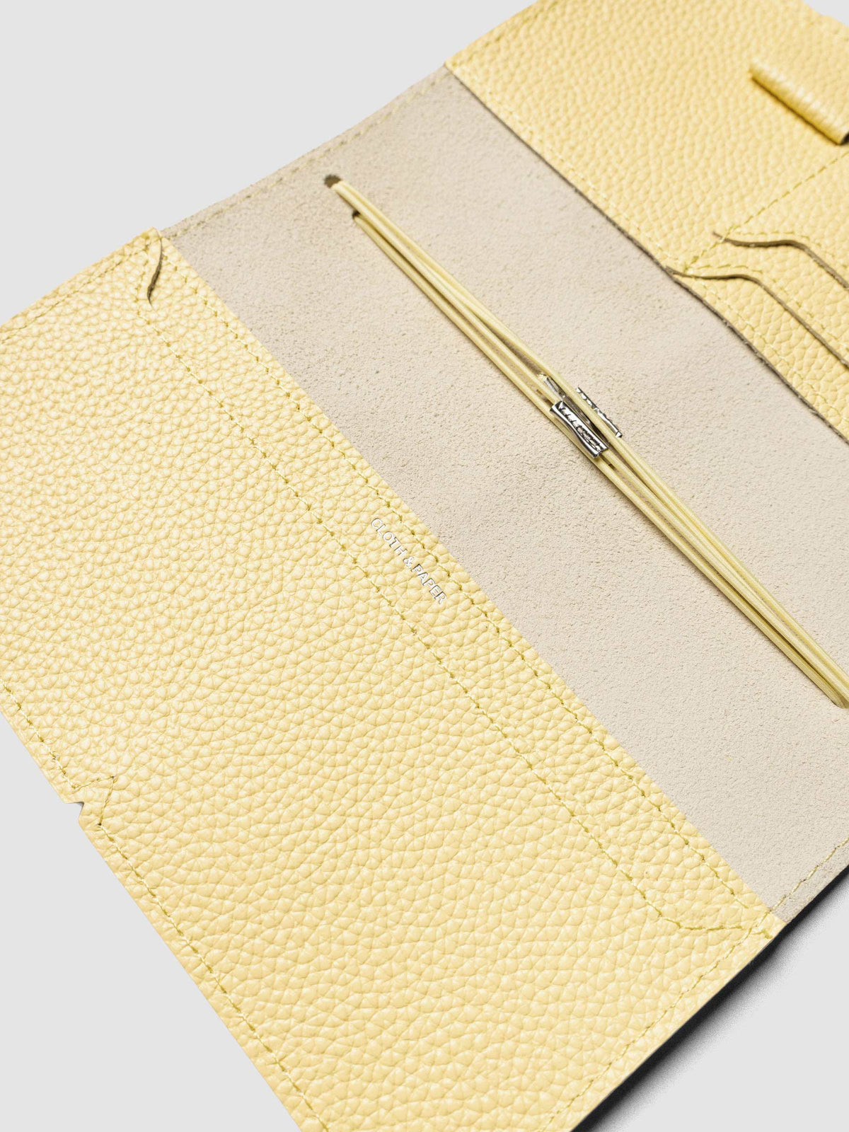 Butter yellow leather travel notebook cover in size Pocket Plus shown open with interior pockes and elastic bands.