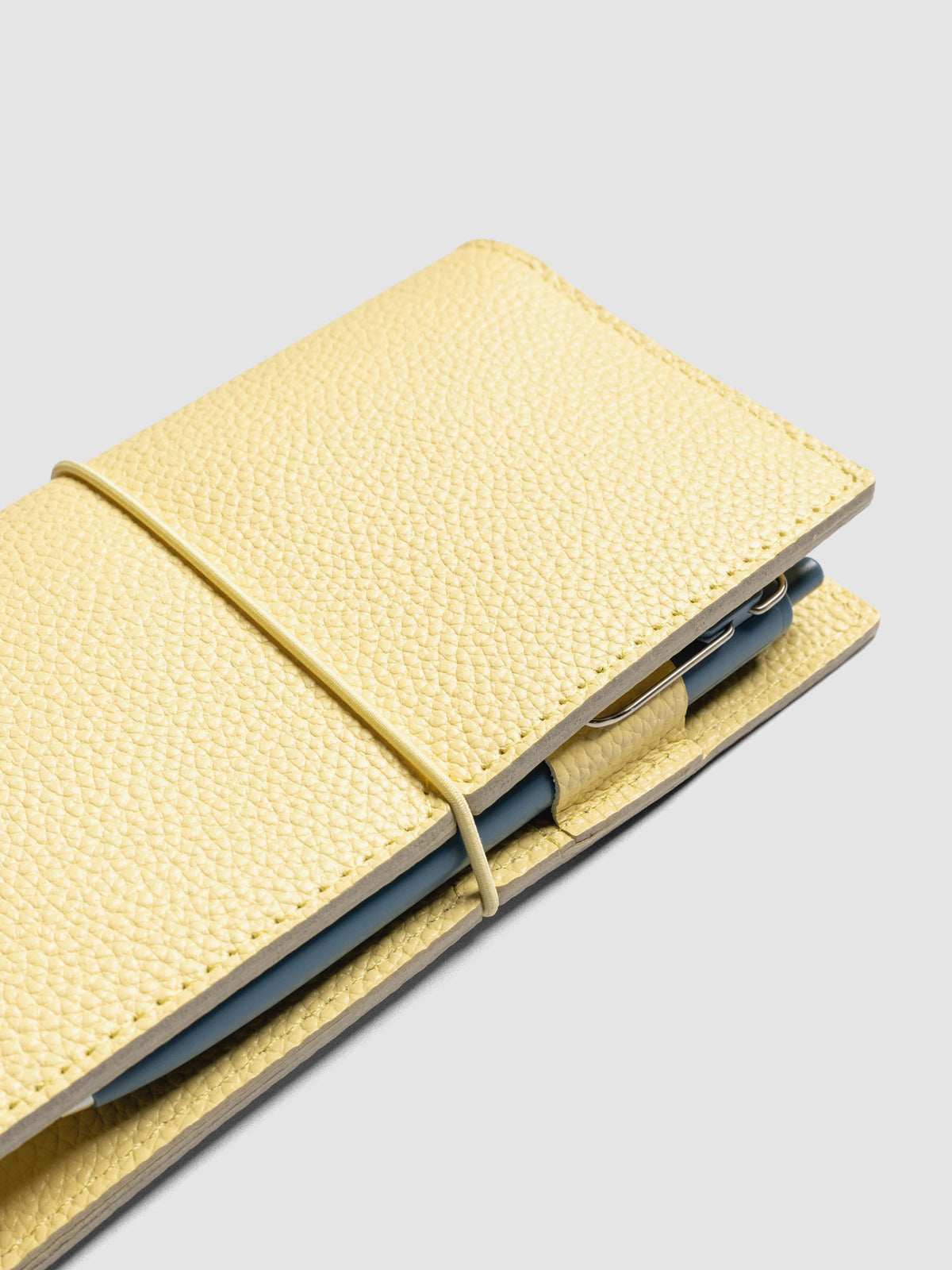 Butter yellow leather travel notebook cover in size Pocket Plus shown open with a pen in the pen loop.