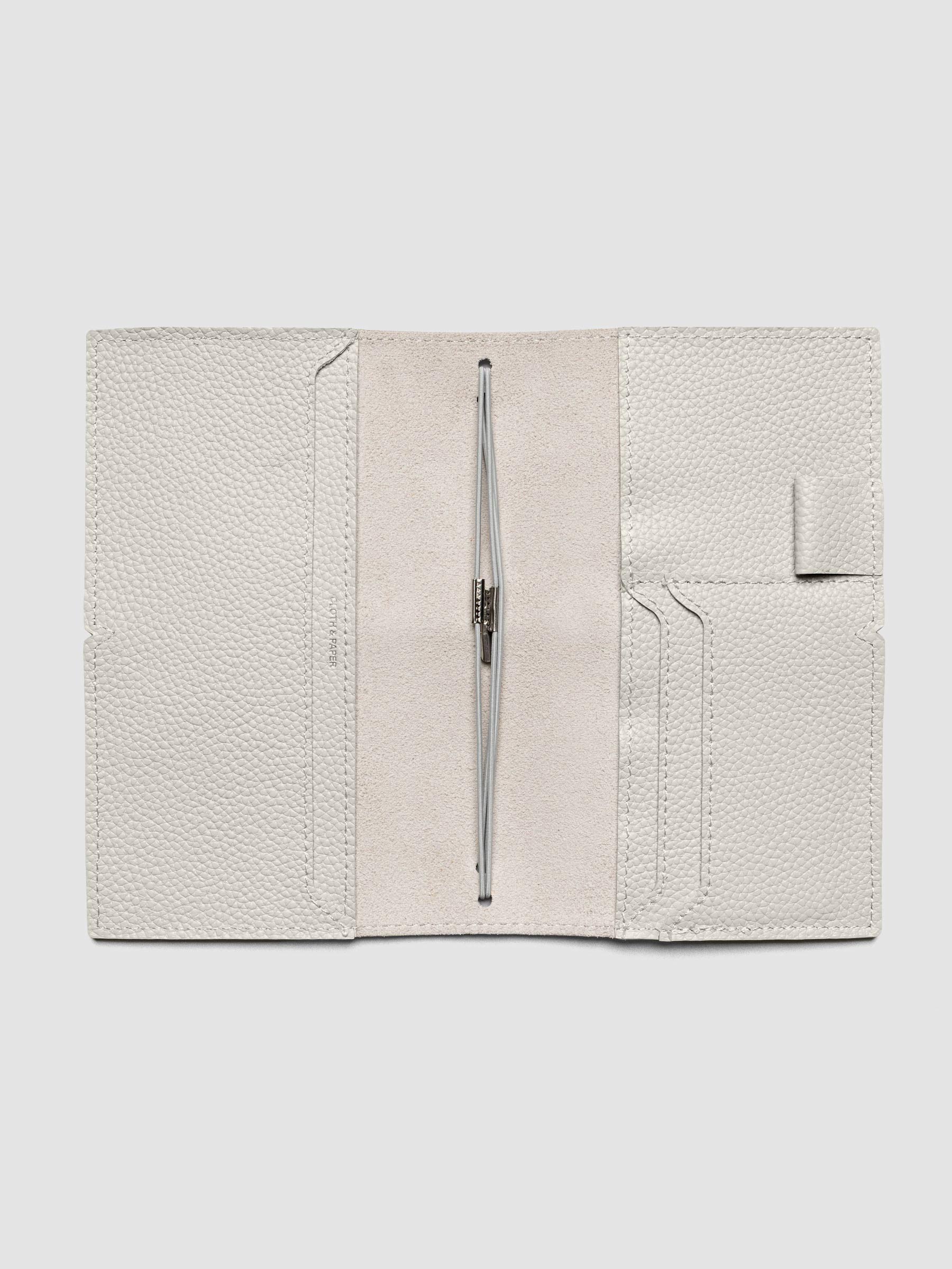 Light grey leather travel notebook cover in size Pocket Plus shown open with interior pockes and elastic bands.