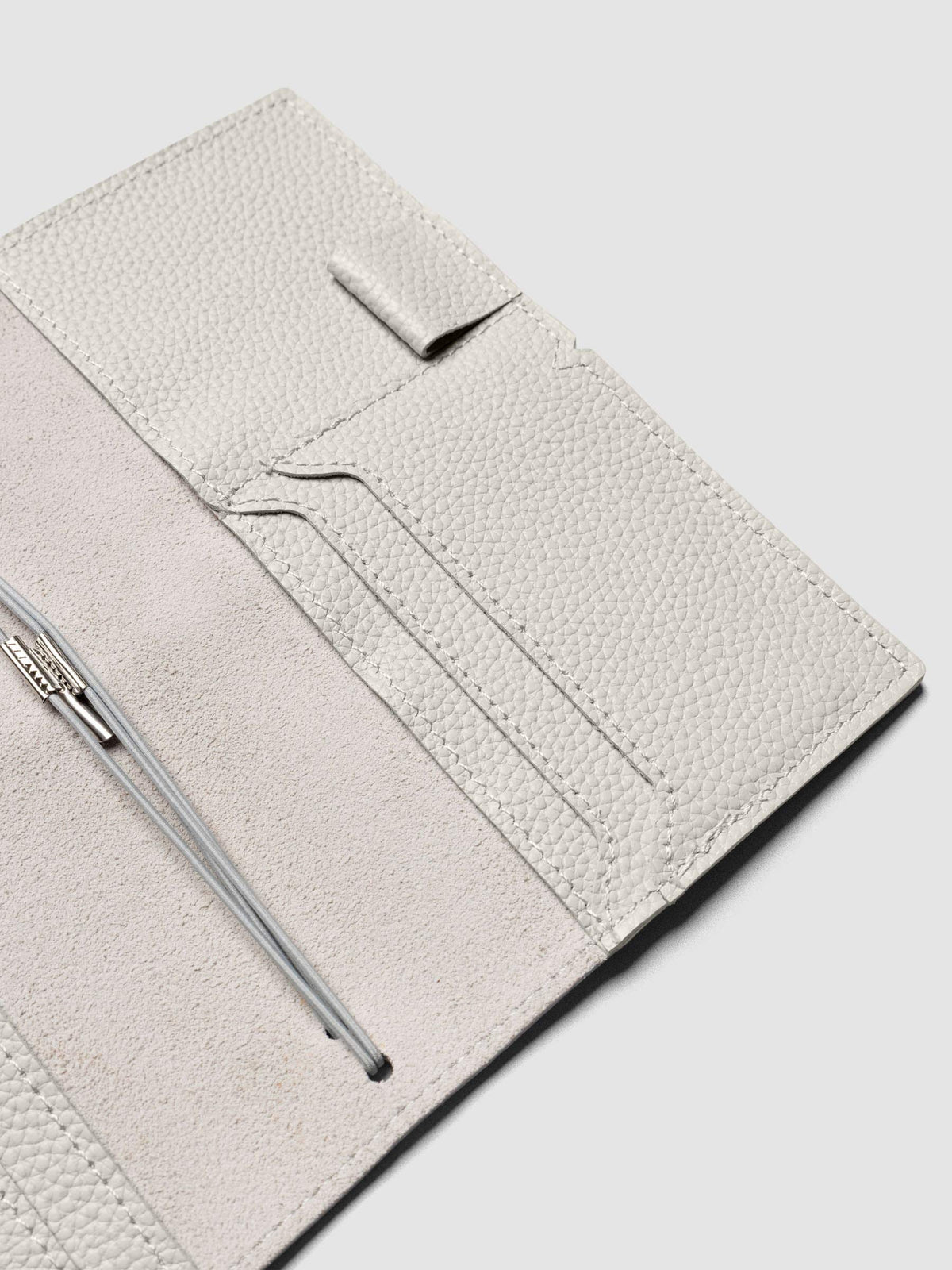 Light grey leather travel notebook cover in size Pocket Plus shown open with interior pockes and elastic bands.