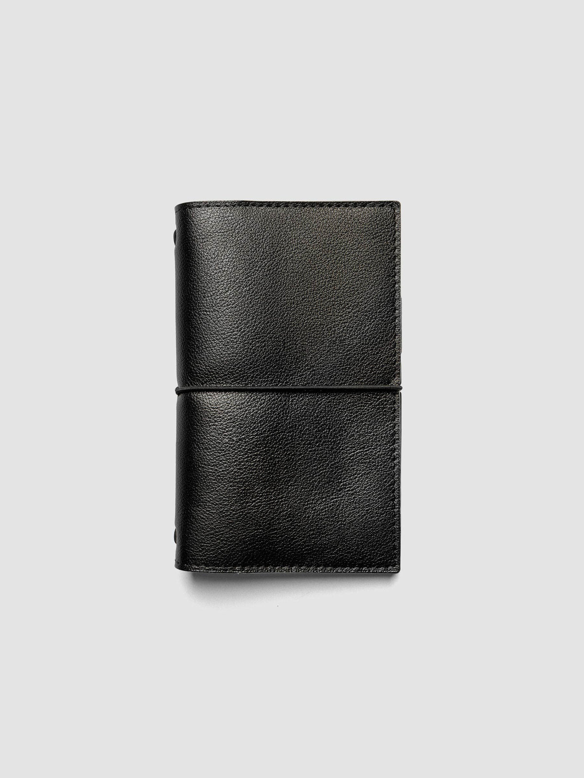 Black genuine leather travel notebook cover shown in size Pocket Plus.