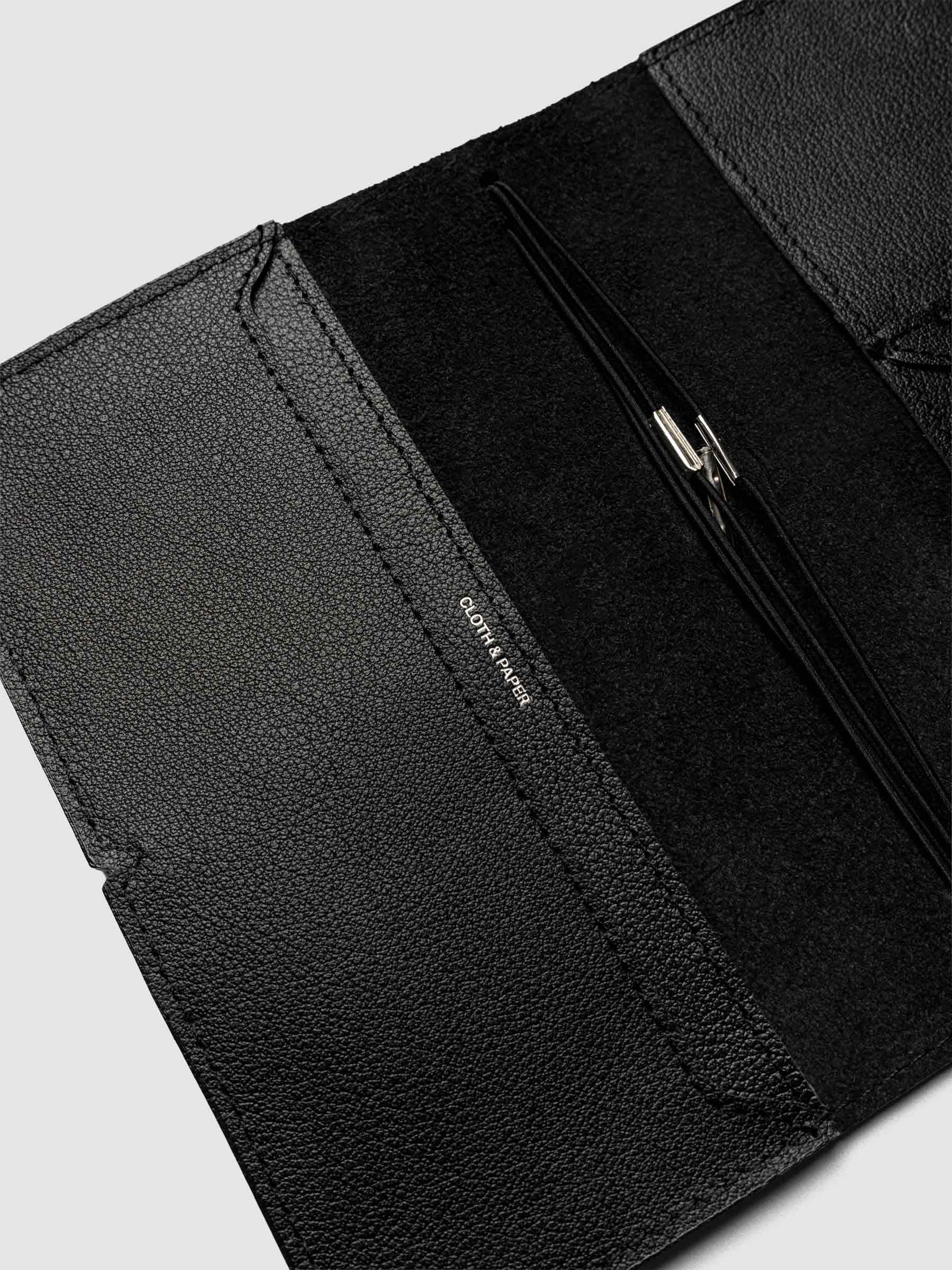 Black leather travel notebook cover in size Pocket Plus shown open with interior pockes and elastic bands.