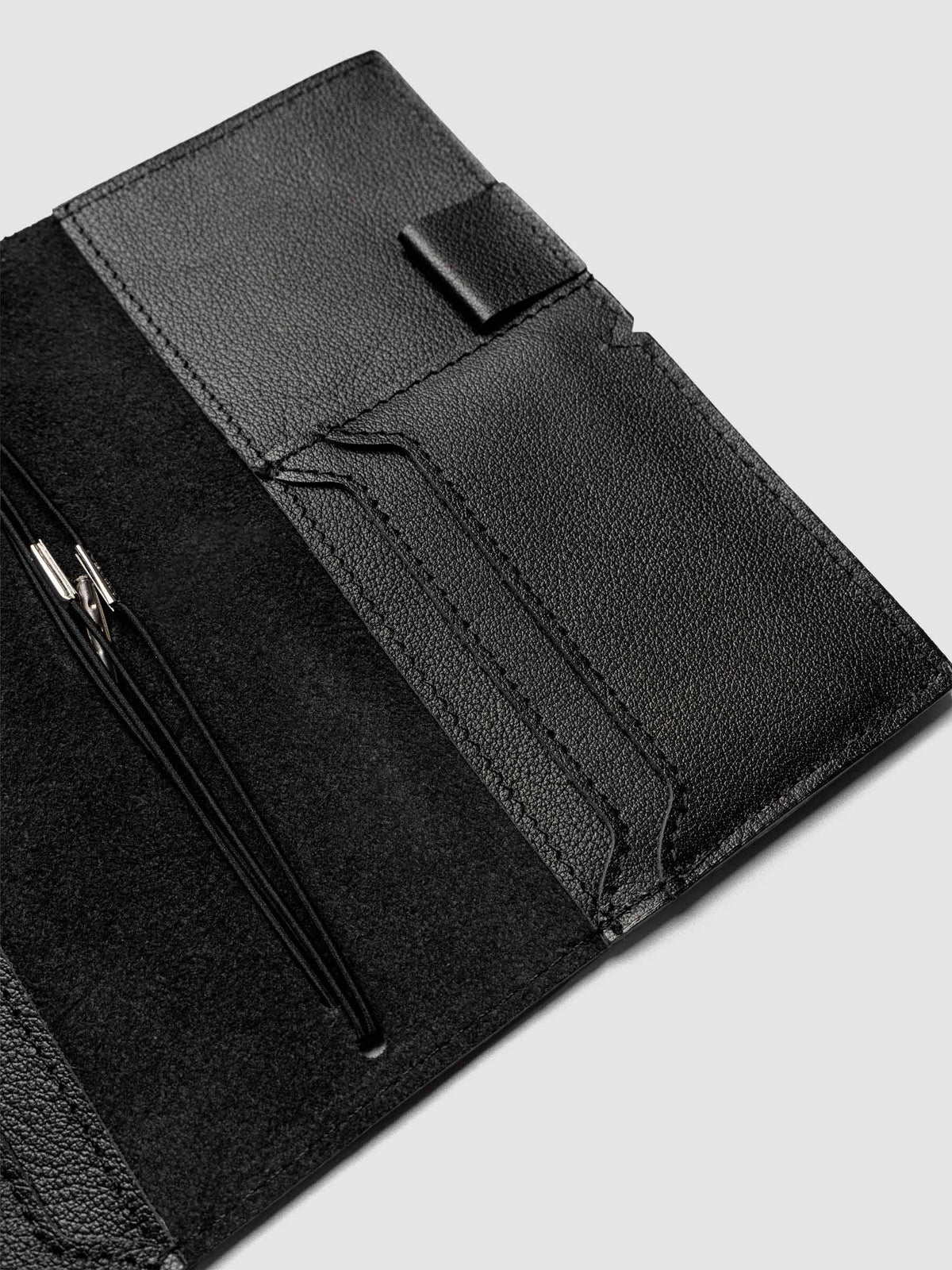 Black leather travel notebook cover in size Pocket Plus shown open with interior pockes and elastic bands.