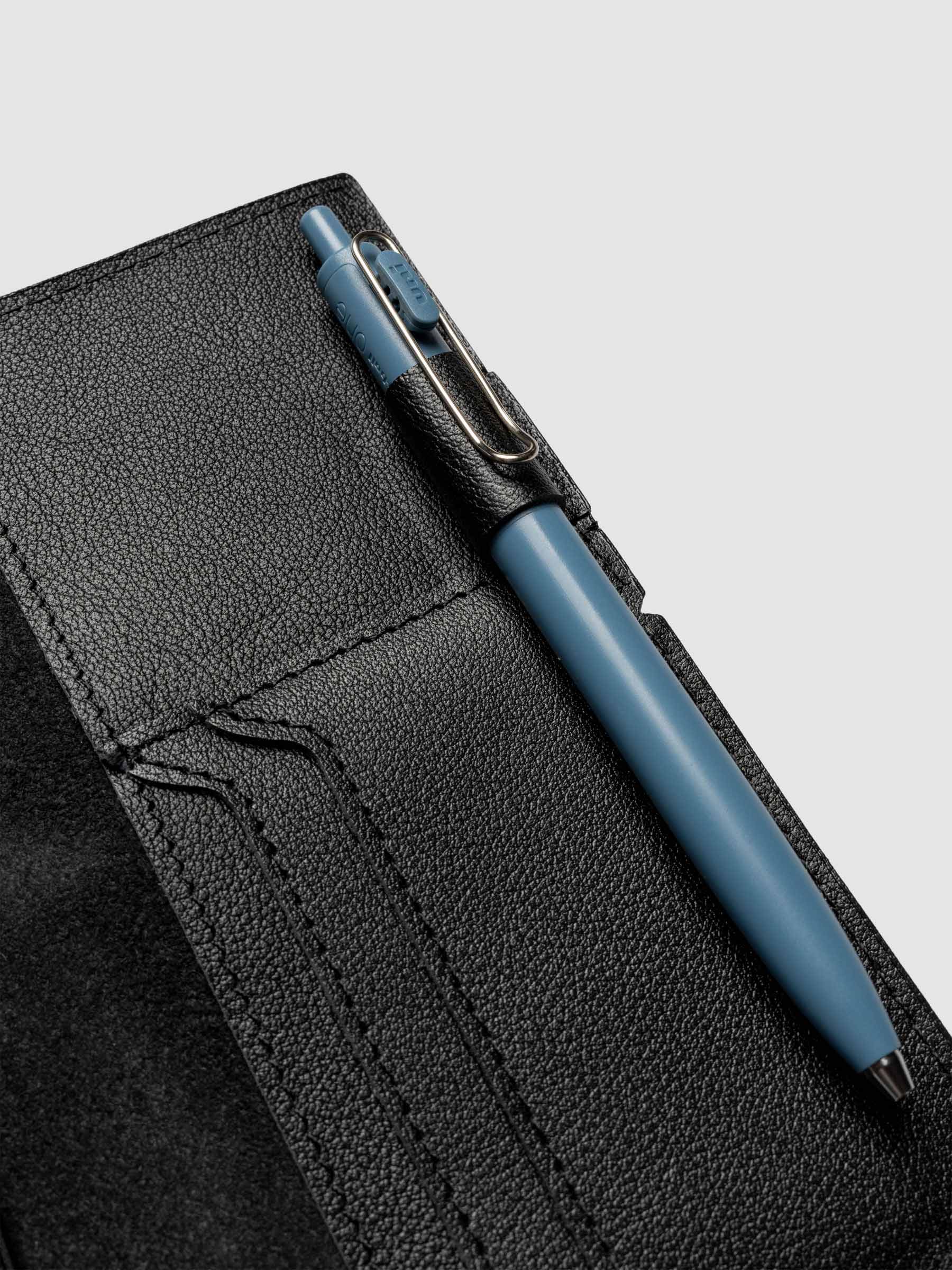 Black leather travel notebook cover in size Pocket Plus shown with travel notebooks inside.