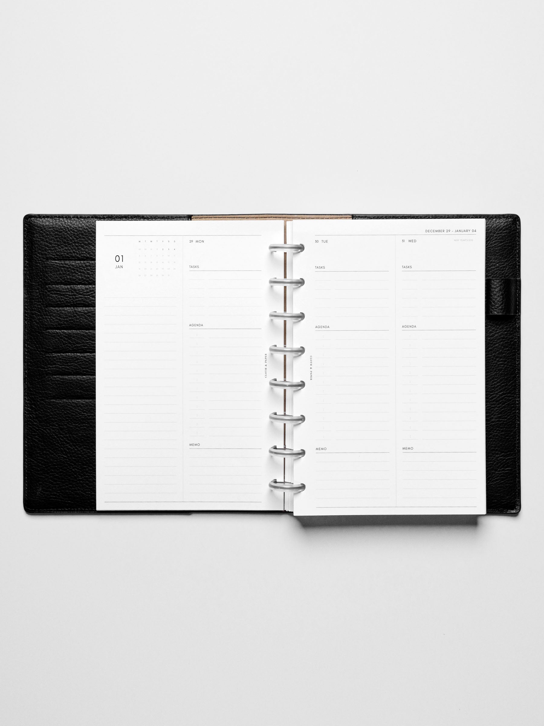 Image shows the Monday Start 2026 Dated Daily Planner Insert in a black leather disc-bound planner.