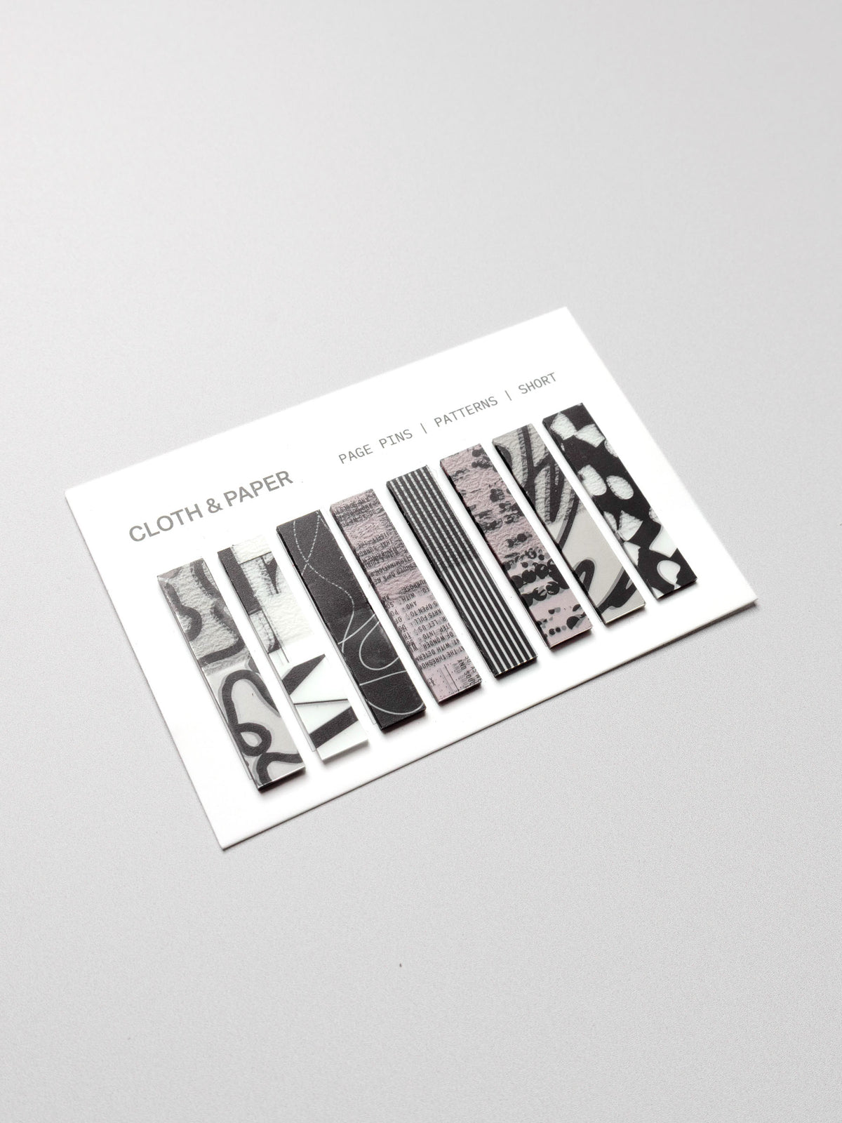 Short page pins displayed in their packaging on a neutral background.